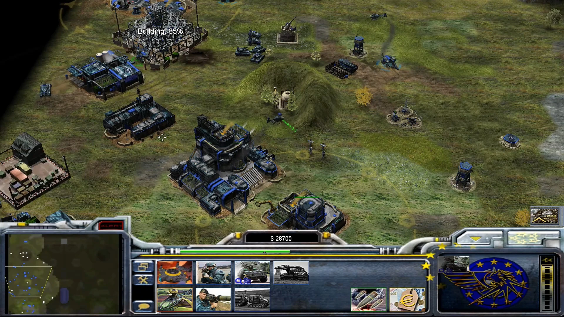 In-game screenshot showing a Command & Conquer Generals base under construction with various buildings, units, and interface visible
