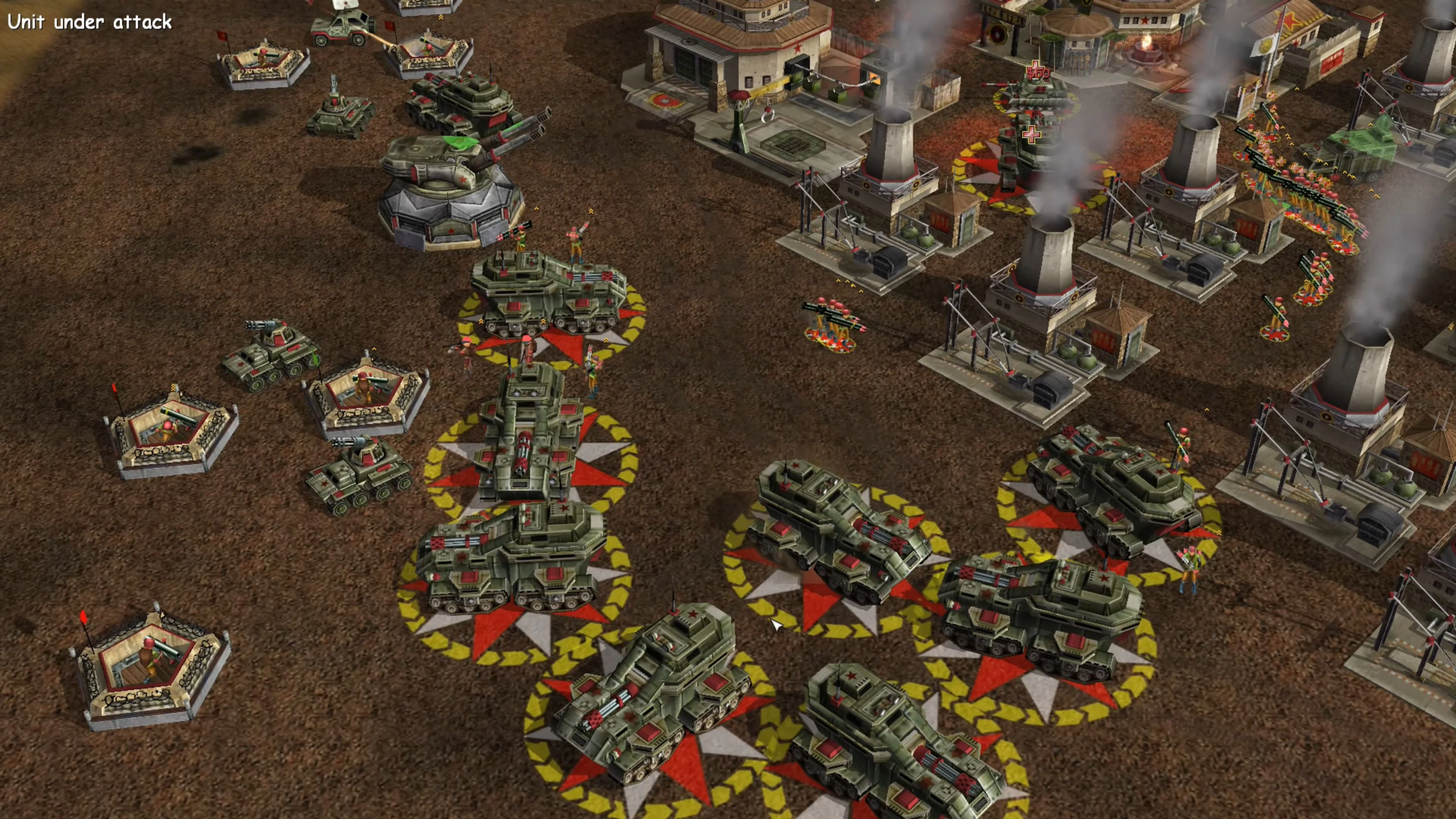 Screenshot vom Shockwave Chaos Mod zeigt Panzer und Infanterie, die eine Basis mit Rauch und Gebäuden verteidigen