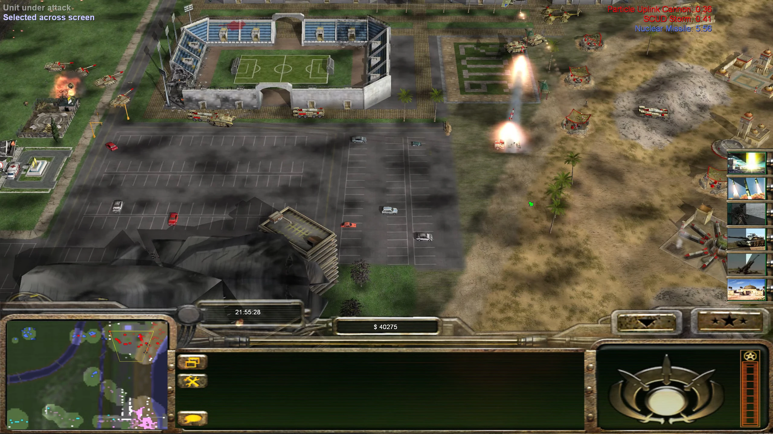 Captura de pantalla de Command & Conquer Generals mod Return mostrando lanzamiento de misiles y ataque a una base cerca de un estadio