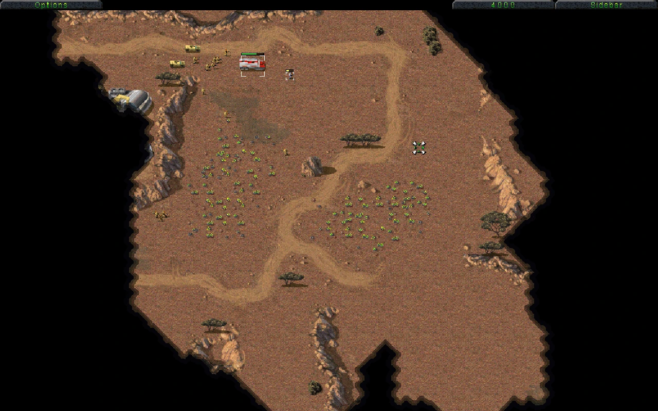 Вид сверху на пустынную карту Command & Conquer с юнитами, постройками и полями тиберия