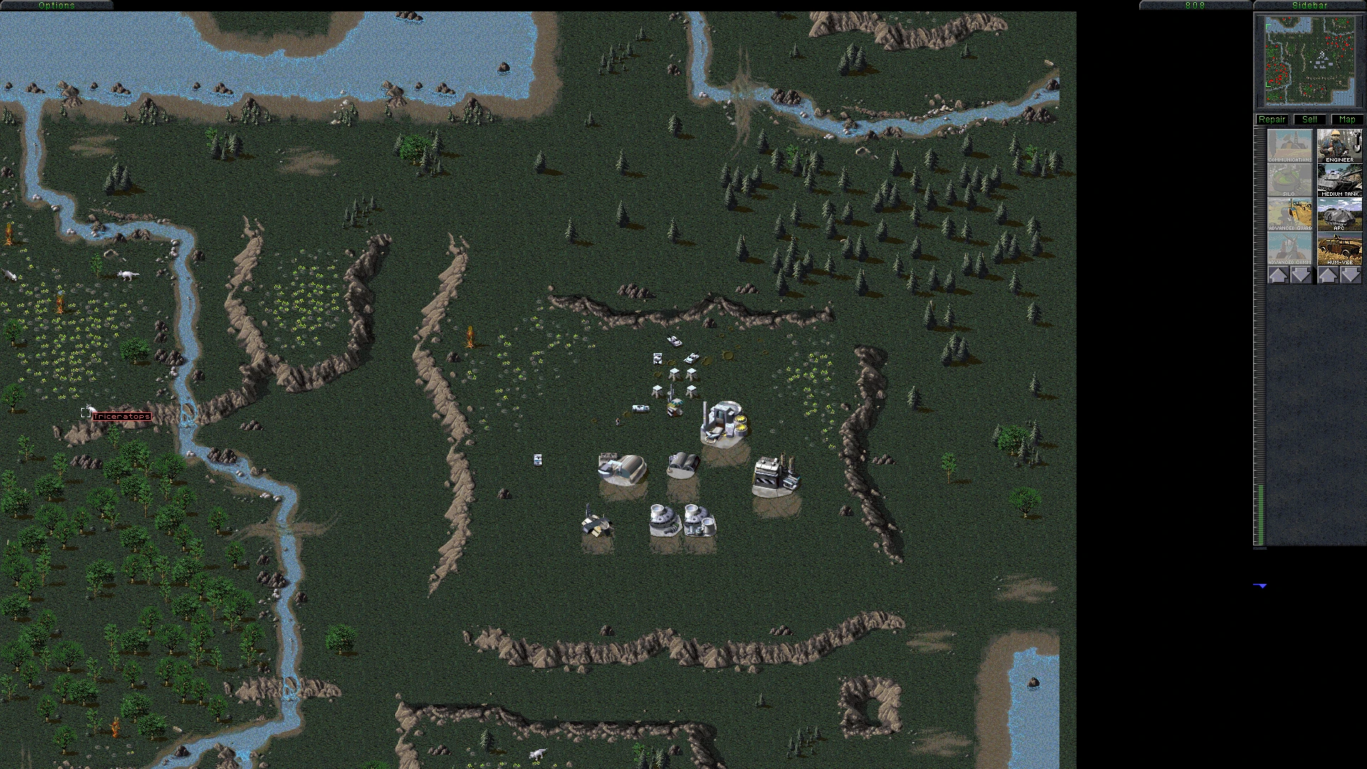 Вид сверху на базу Command & Conquer Tiberian Dawn с постройками и юнитами возле леса и реки