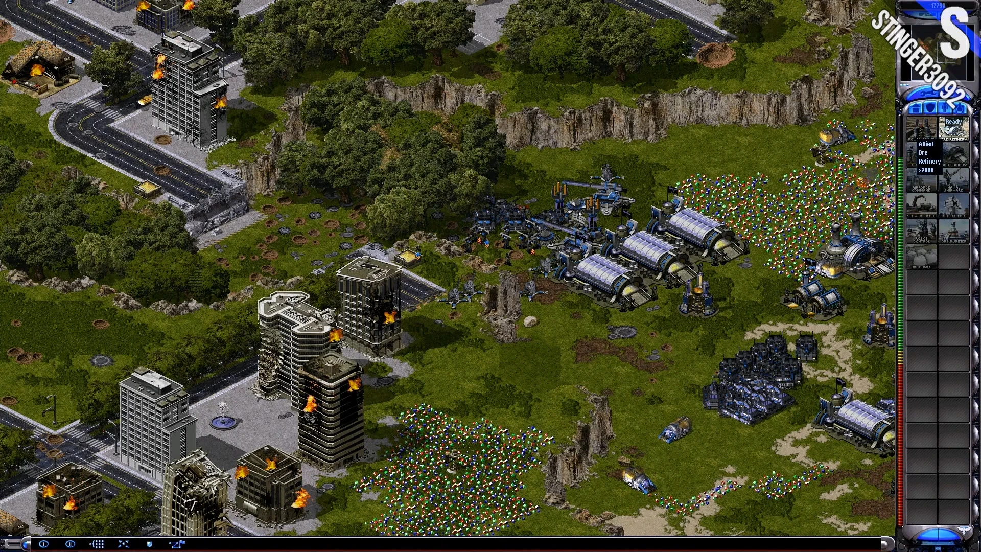 Скриншот Command & Conquer Yuri's Revenge с детальной боевой сценой, горящими зданиями, военными единицами и ресурсами