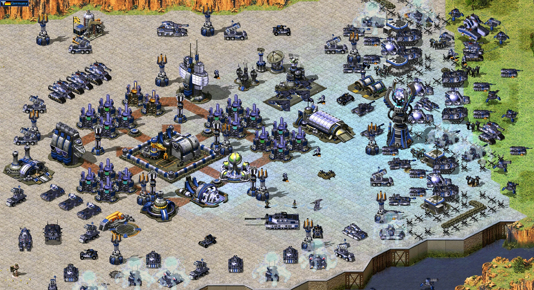 Zrzut ekranu przedstawiający rozbudowaną bazę wojskową z czołgami, wieżyczkami i różnymi jednostkami w modzie Reboot do Yuri's Revenge