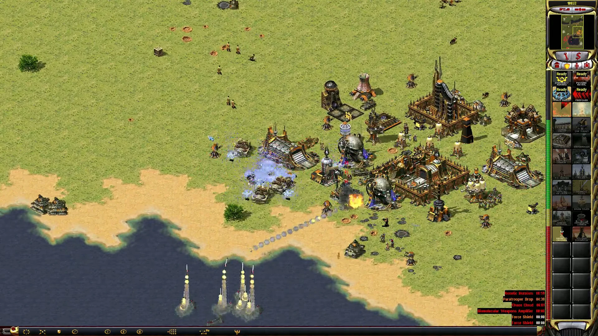 Gameplay screenshot showing heavy artillery attacking a base with buildings and units in Red Alert 2 Apocalypse mod