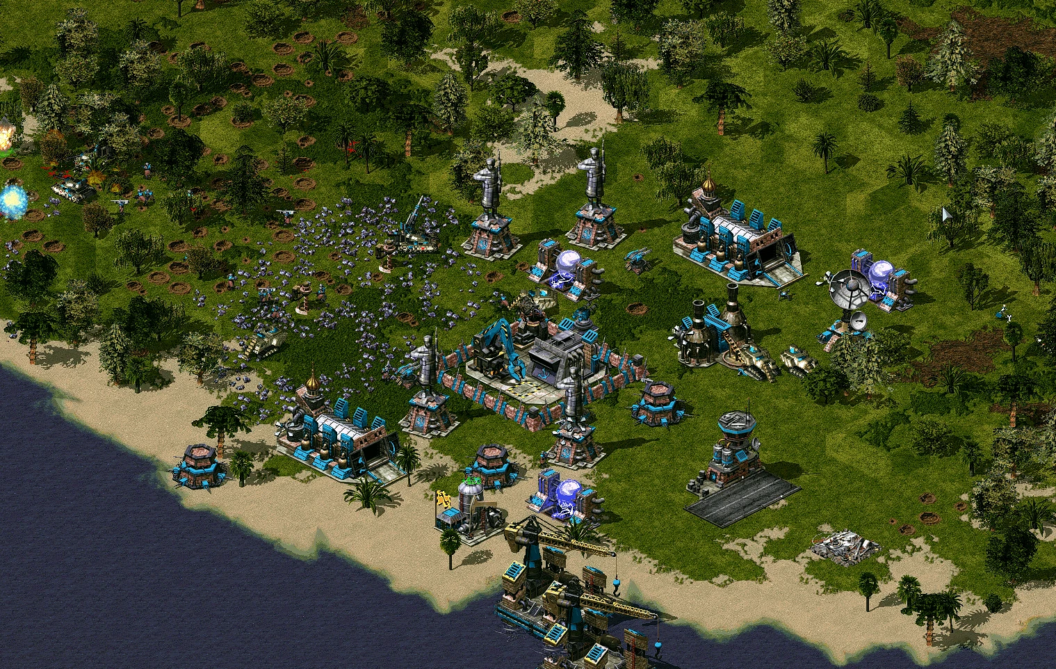 Скриншот Command & Conquer Yuri's Revenge с прибрежной базой, множеством зданий, турелей и юнитов на зеленом ландшафте