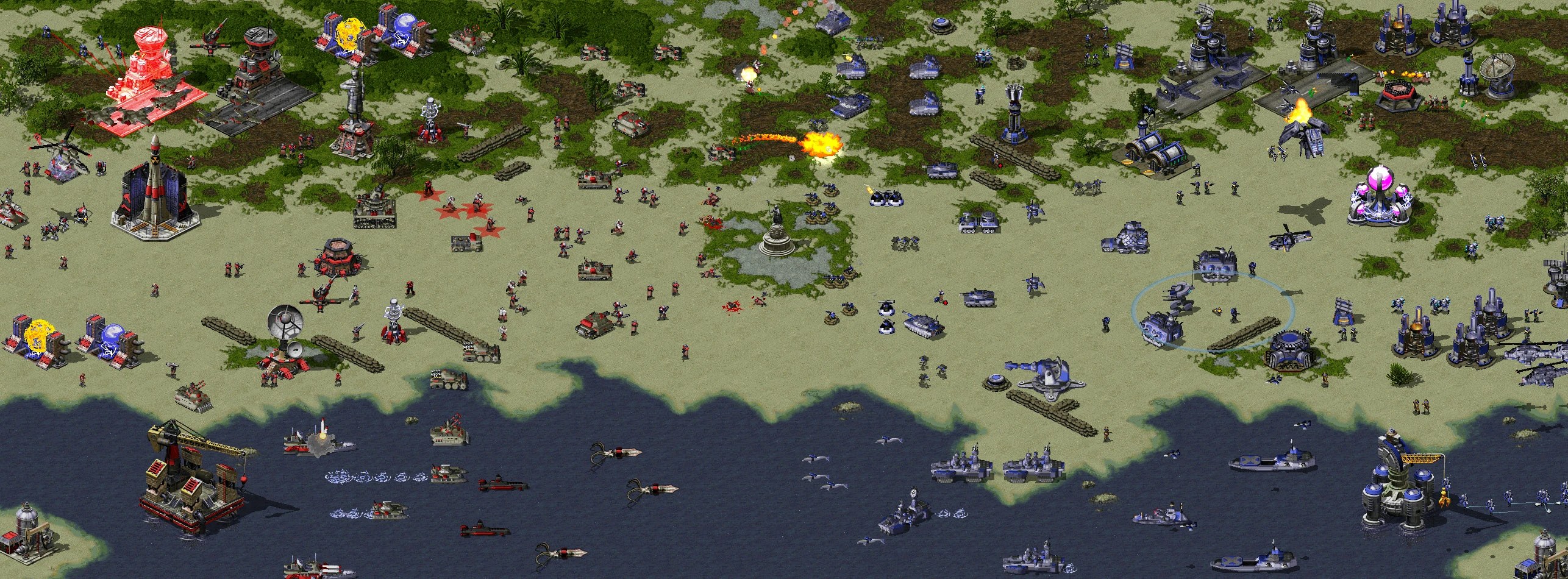 Vista cenital de fuerzas rojas y azules enfrentándose con infantería, tanques, aeronaves y unidades navales en terreno costero