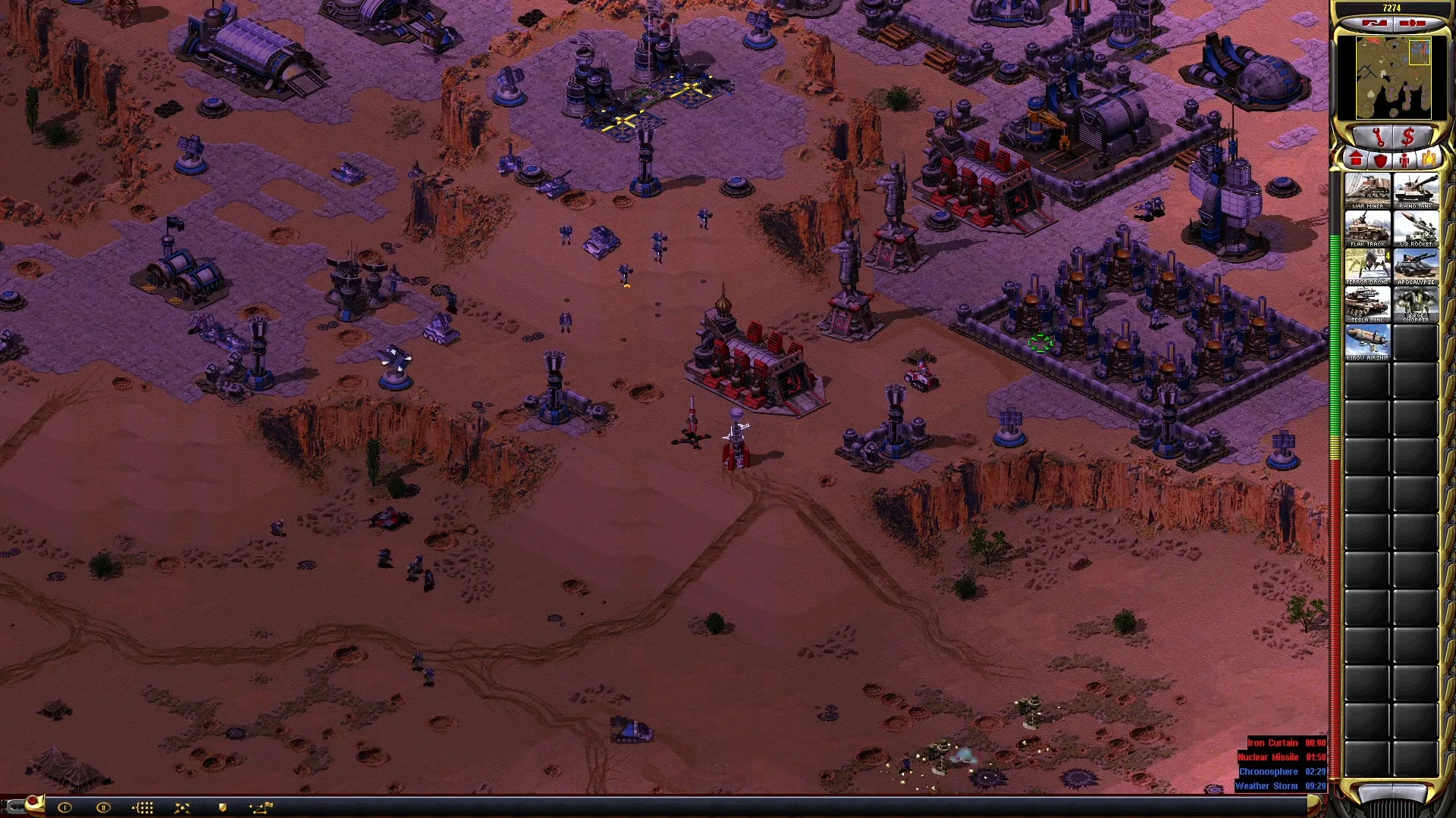 Captura de pantalla dentro del juego mostrando una base fortificada en el desierto con múltiples estructuras defensivas y unidades en Yuri's Revenge - Re-Engagements