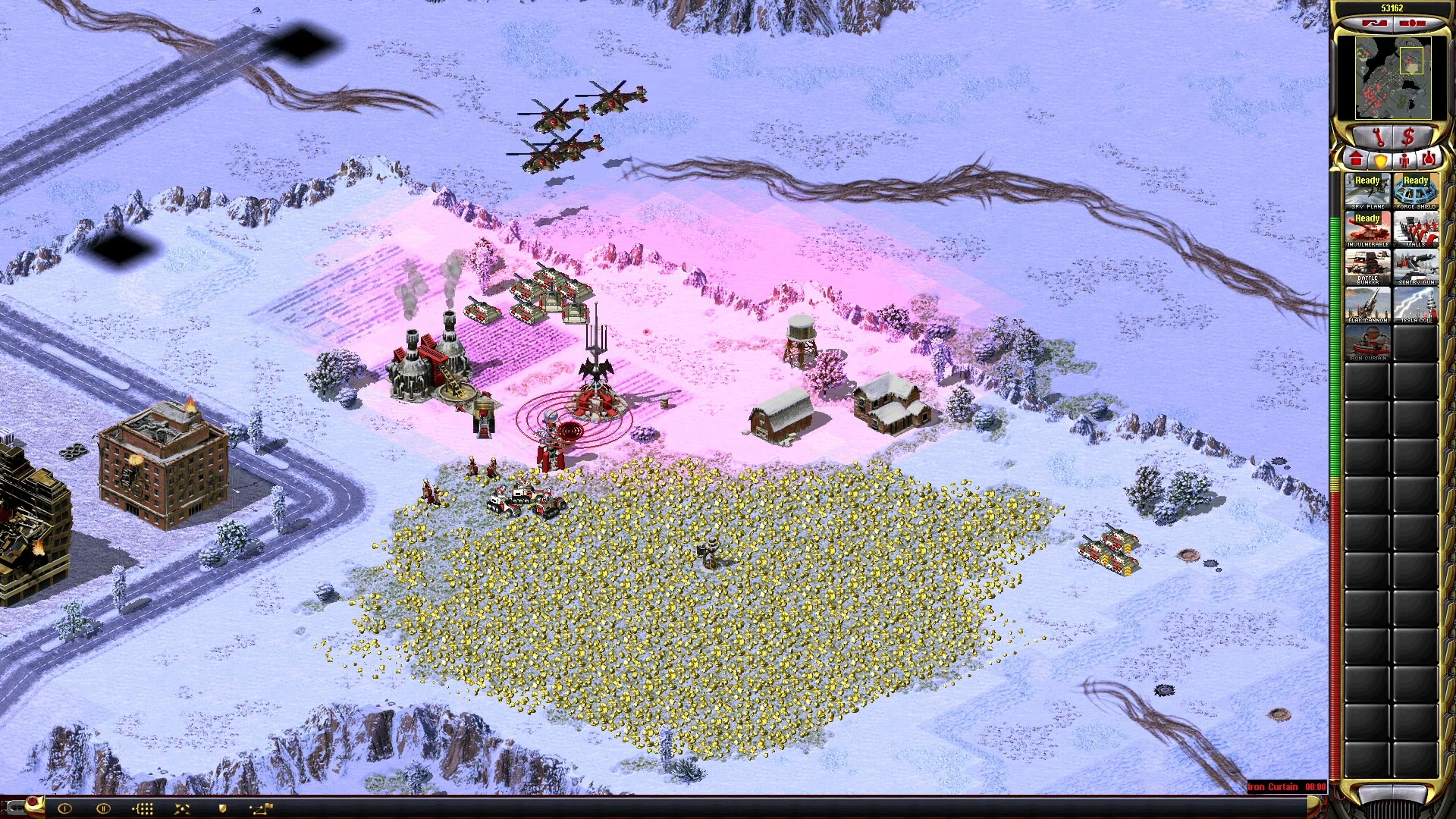 Captura del mod Yuri's Revenge con terreno nevado, base militar, helicópteros, tanques y campo de recursos