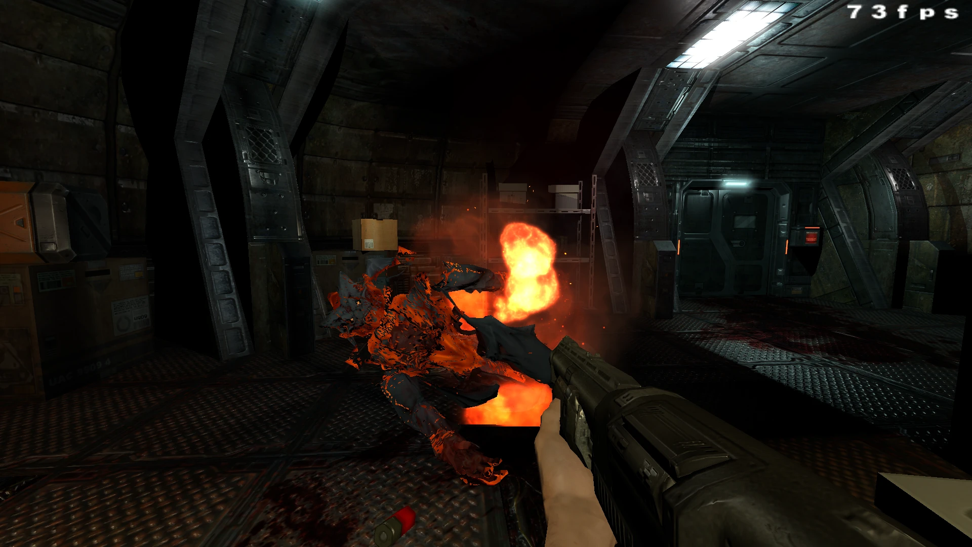 Вид від першої особи в Doom 3, що показує, як дробовик стріляє по палаючому монстру в темній промисловій кімнаті