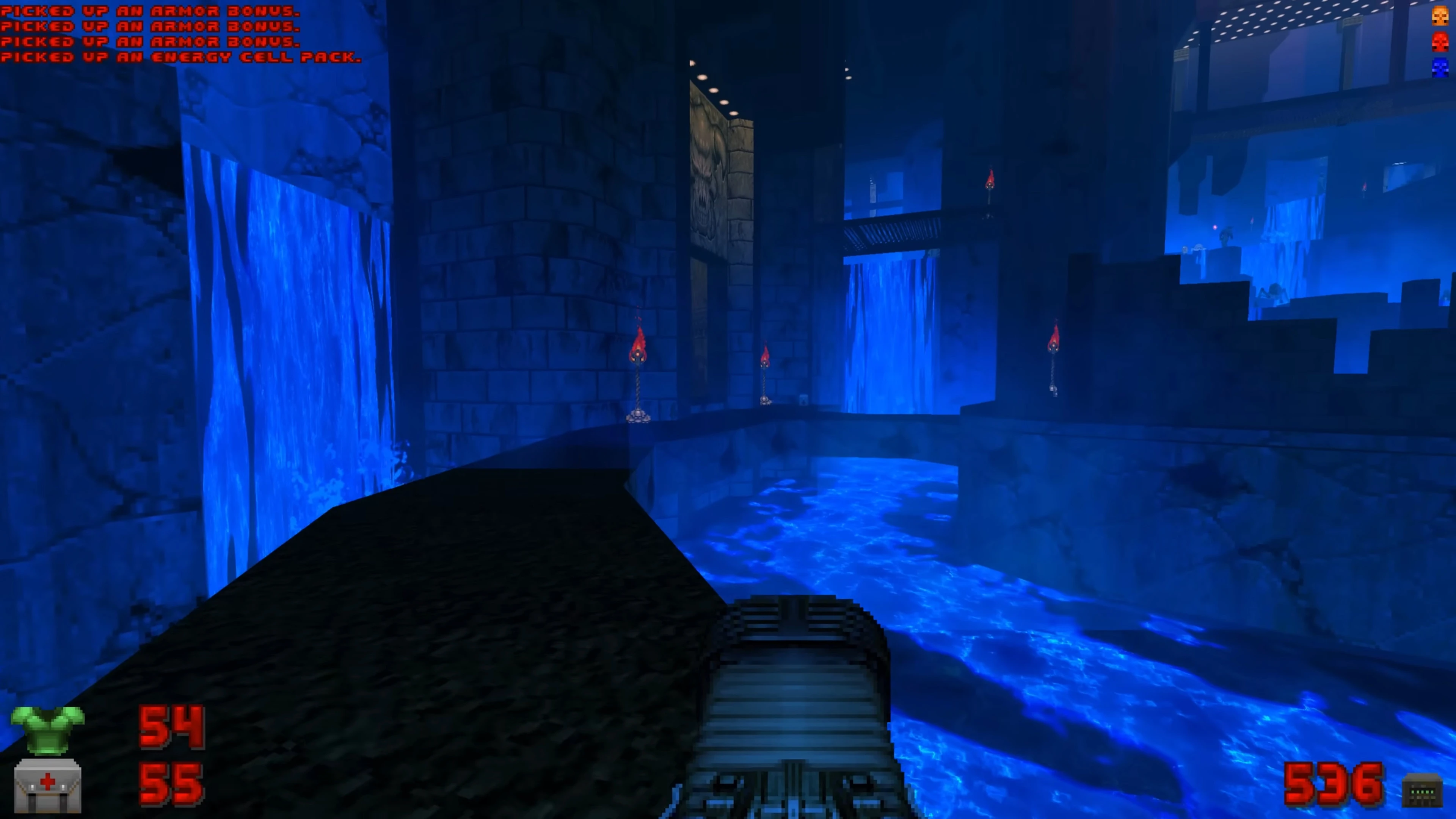Vista en primera persona en Doom II con texturas líquidas azules fluyendo dentro de un castillo oscuro con antorchas
