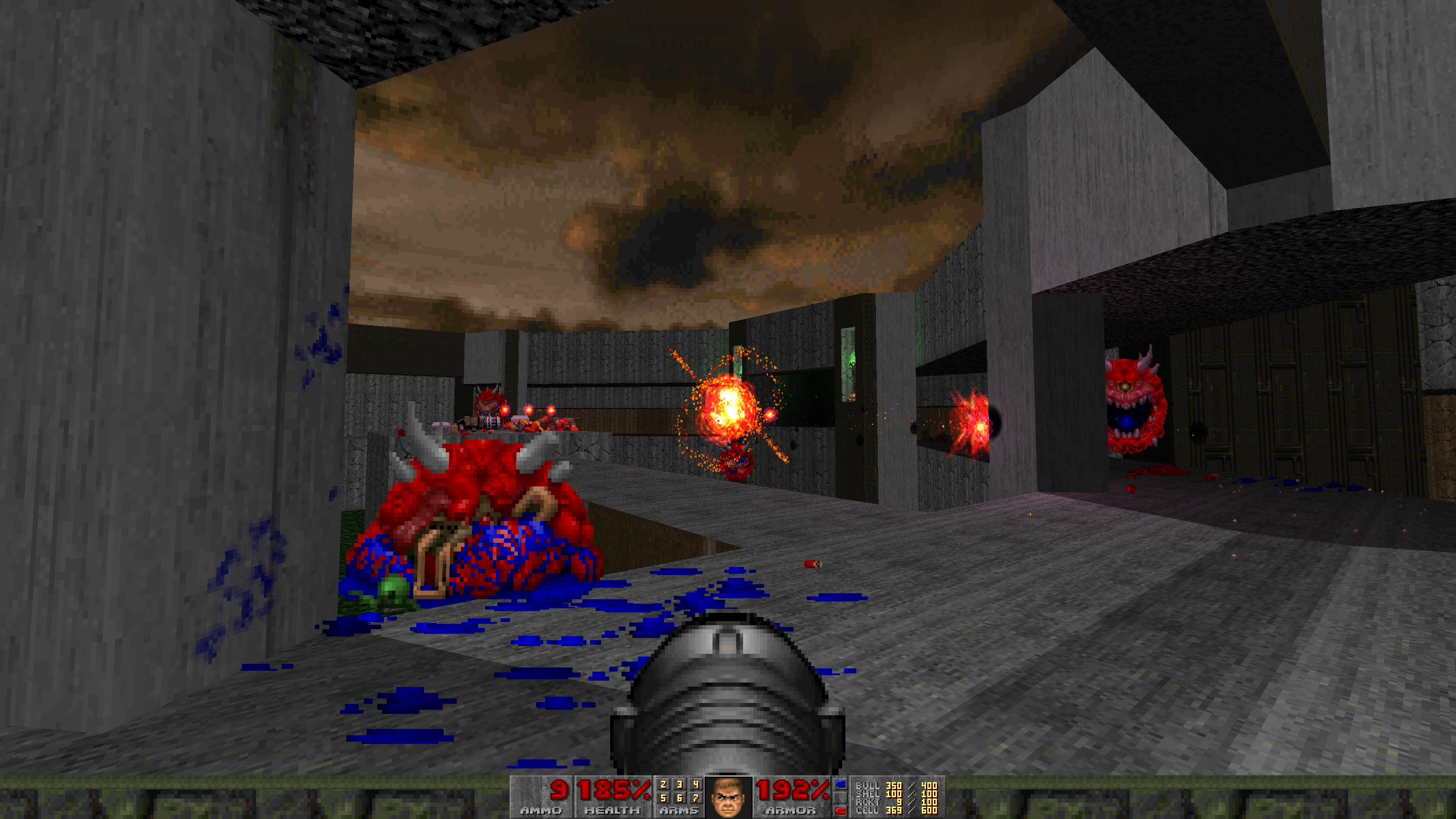 Player facing multiple fireball-launching demons in a gray concrete interior Doom II mod level