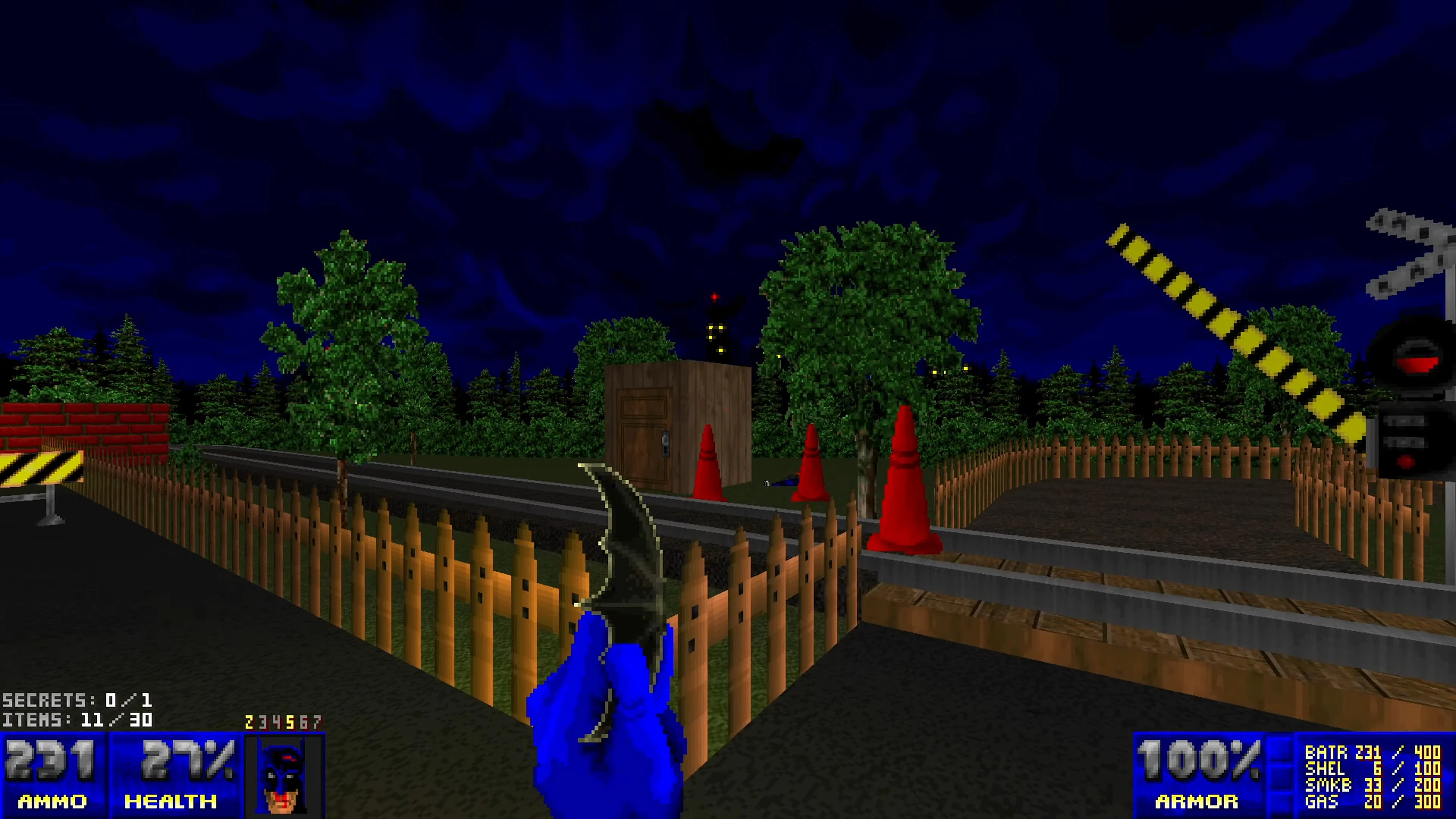 First-person view with Batman glove and knife near a wooden fence and train tracks at night in Doom II mod