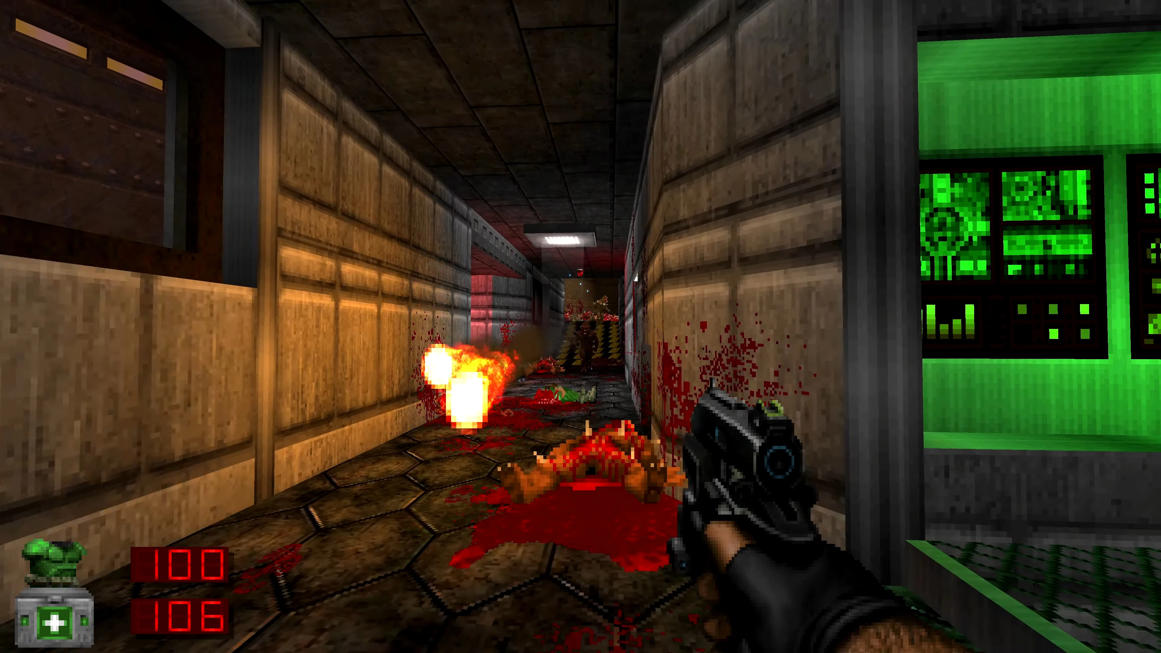 First-person view of player shooting in a blood-splattered industrial corridor with green computer monitors