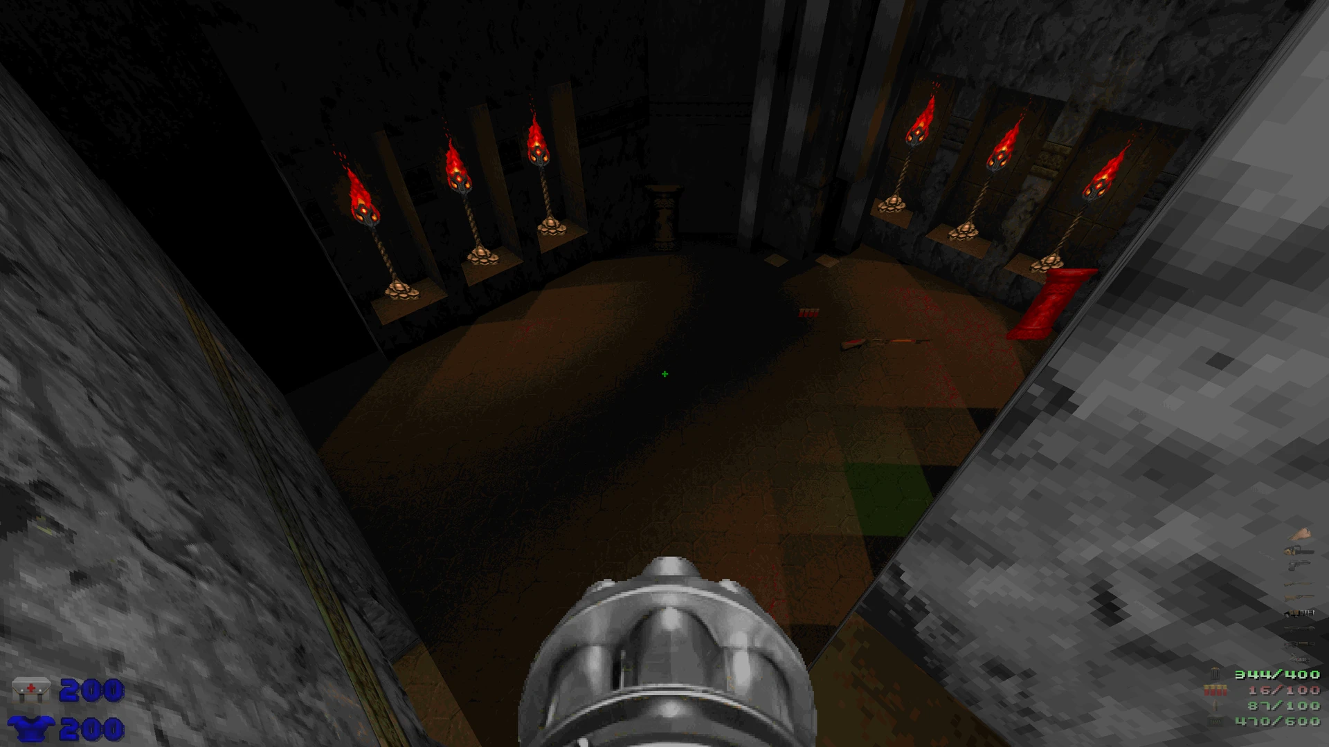 Вид від першої особи в Doom II з модом Doom Neural Upscale 2X, темна кругла кімната зі запаленими факелами та мініганом