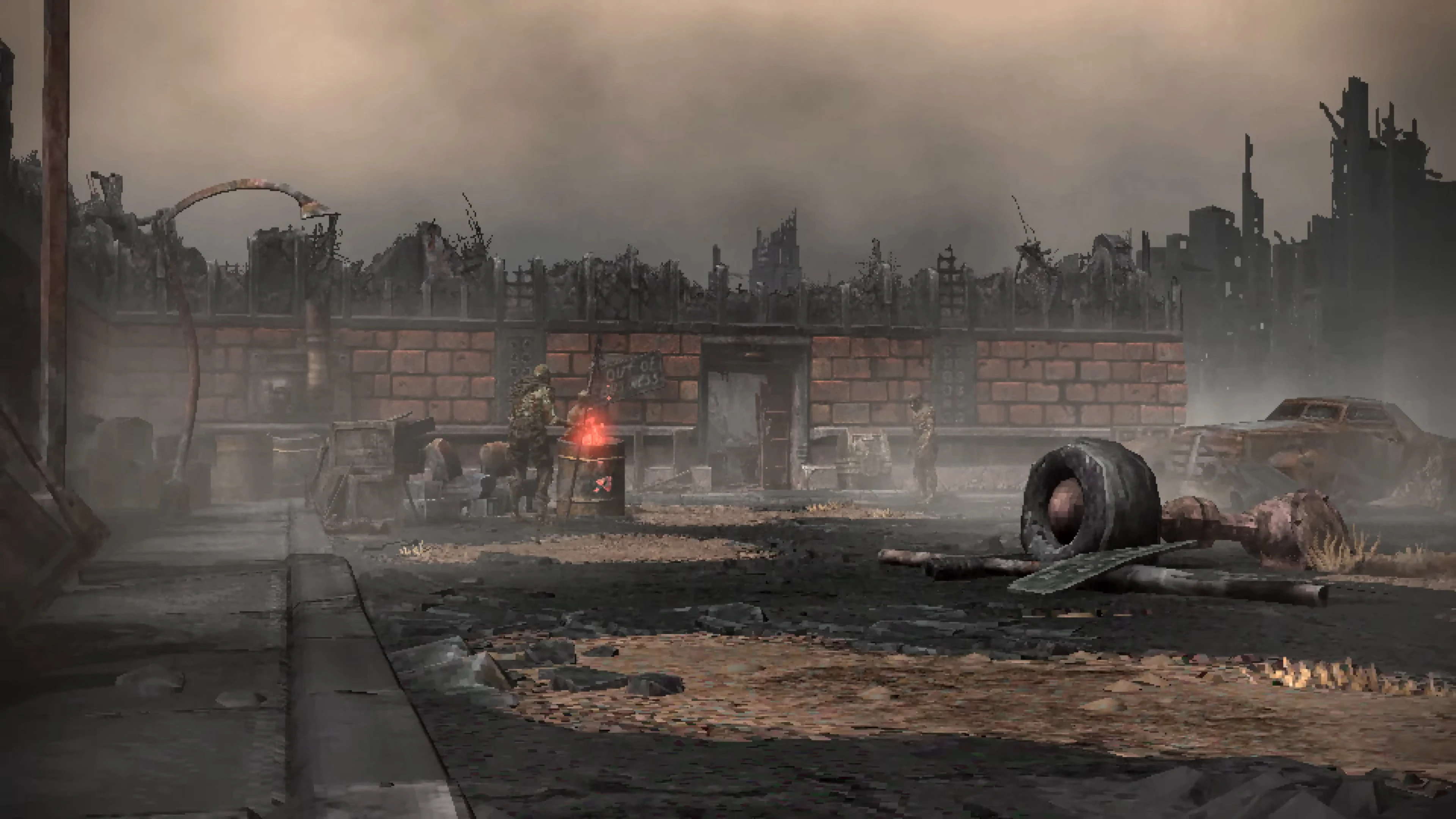 Foggy wasteland scene with ruined buildings, rusted cars, and figures near a burning barrel in Fallout Bakersfield mod