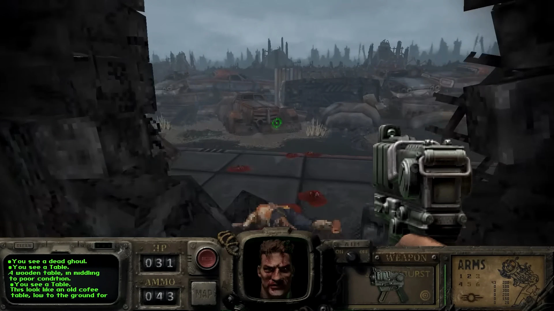 First-person view showing a futuristic gun and a dead ghoul in a ruined city environment in Fallout Bakersfield mod