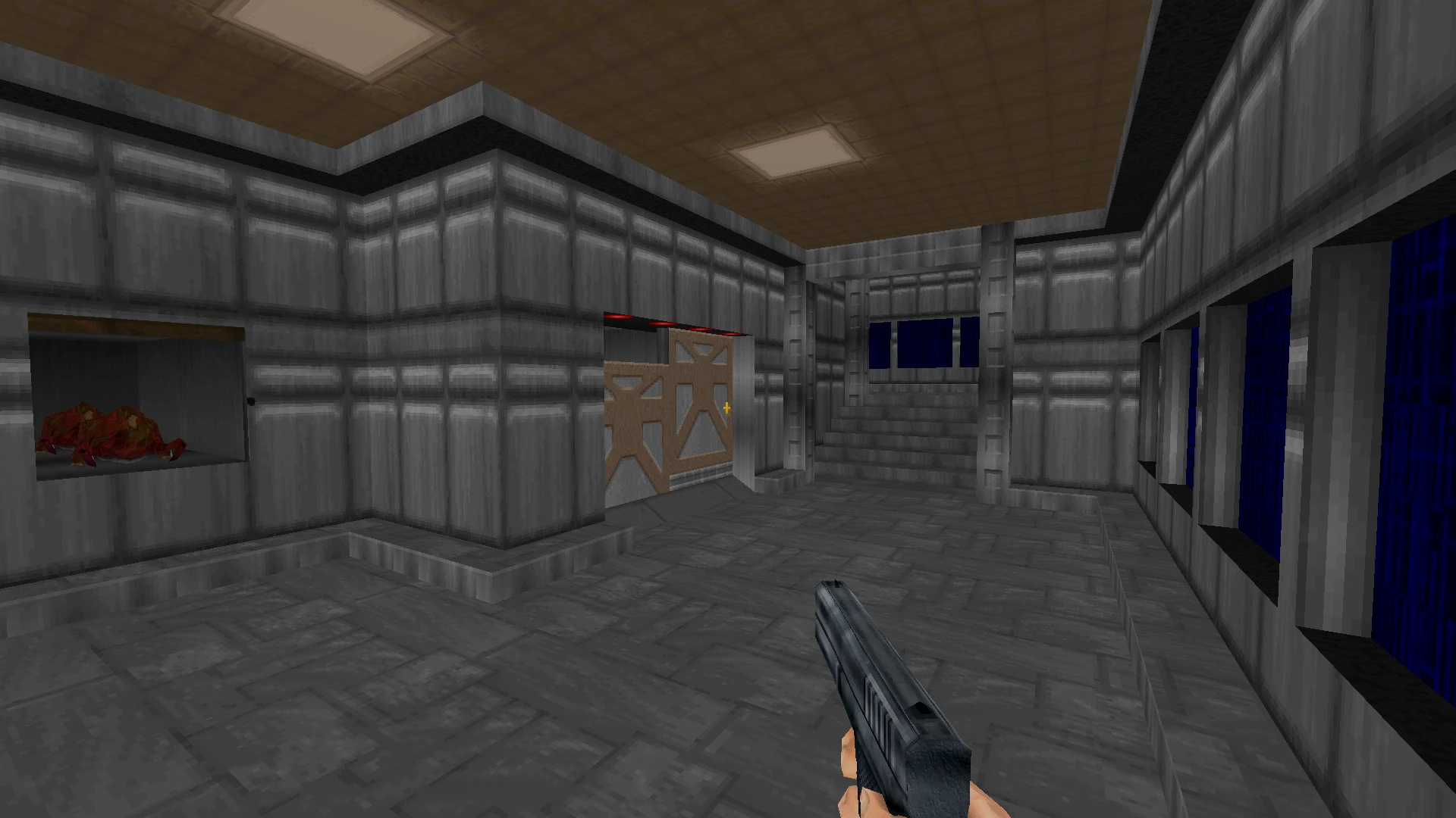 Una escena de pasillo del mod Half-Life: Alpha en el motor de Doom II, mostrando una pistola en la mano del jugador, paredes metálicas y una puerta cerrada.