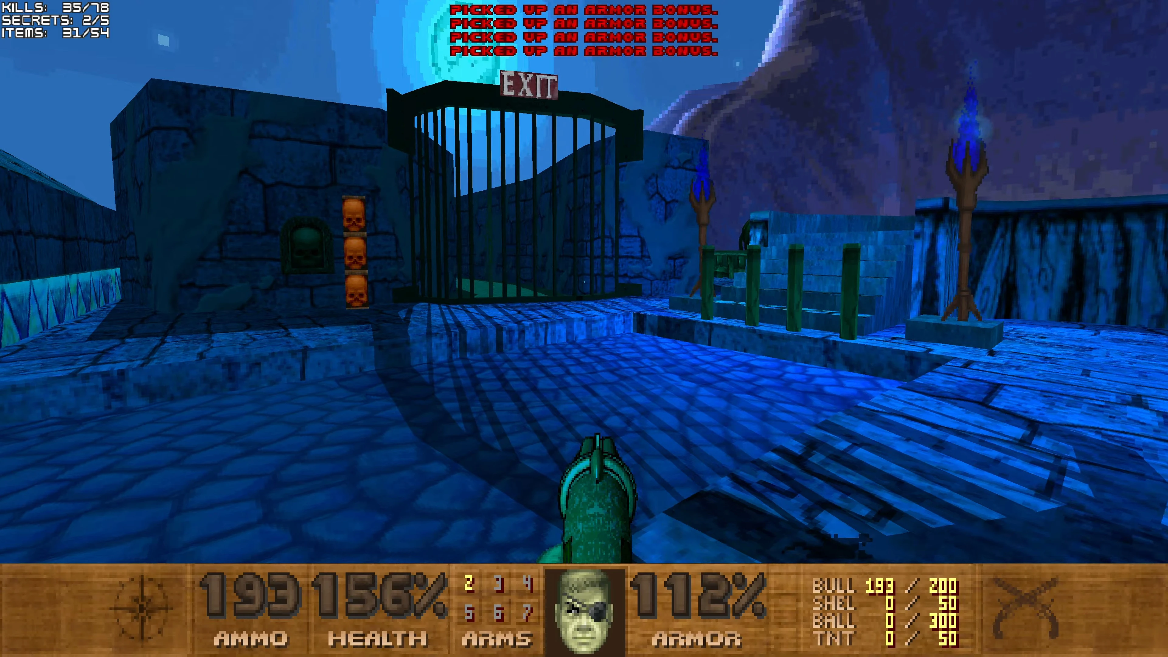 First-person view of Doom II Pirate Doom mod showing the final exit gate with blue flame torches and player HUD with ammo and health