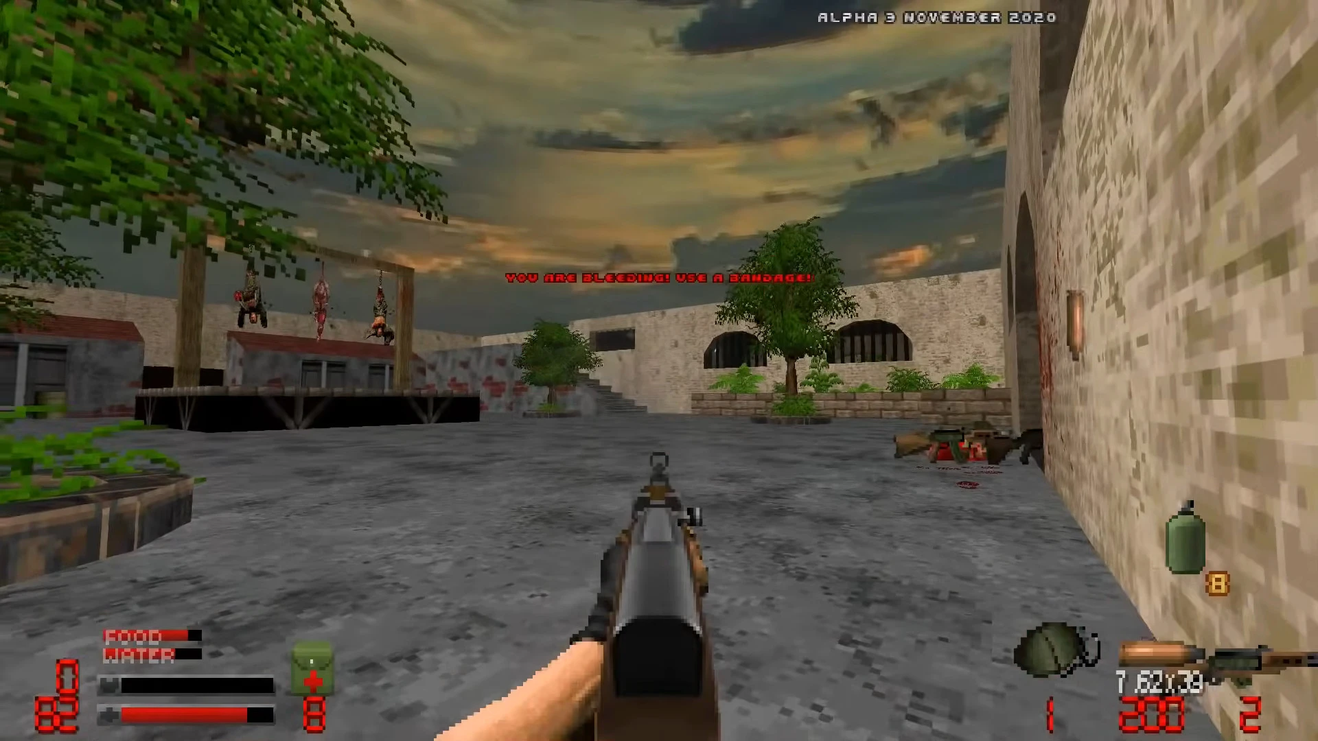 First-person view of a player holding a rifle in a grey concrete courtyard with hanging bodies and bleeding warning message