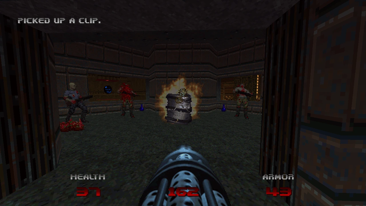 El jugador dispara con ametralladora a enemigos en una sala estrecha con munición y explosiones – del mod Doom 64: Unseen Evil