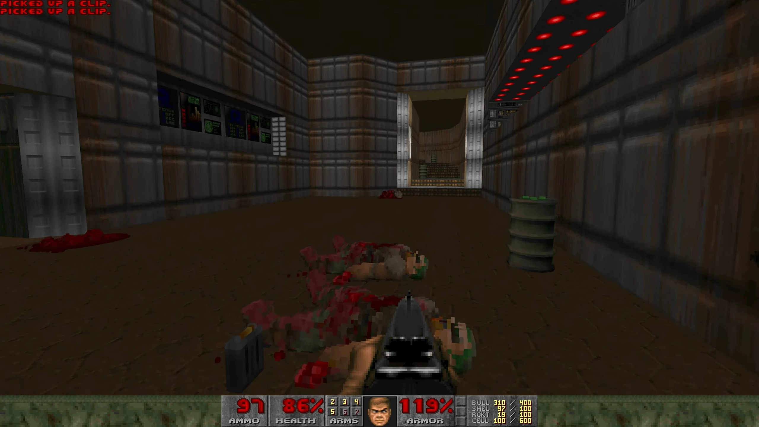 First-person view inside a tech-themed Doom 1993 level showing dead enemies and game HUD with ammo, health, and armor stats in Voxel Doom mod