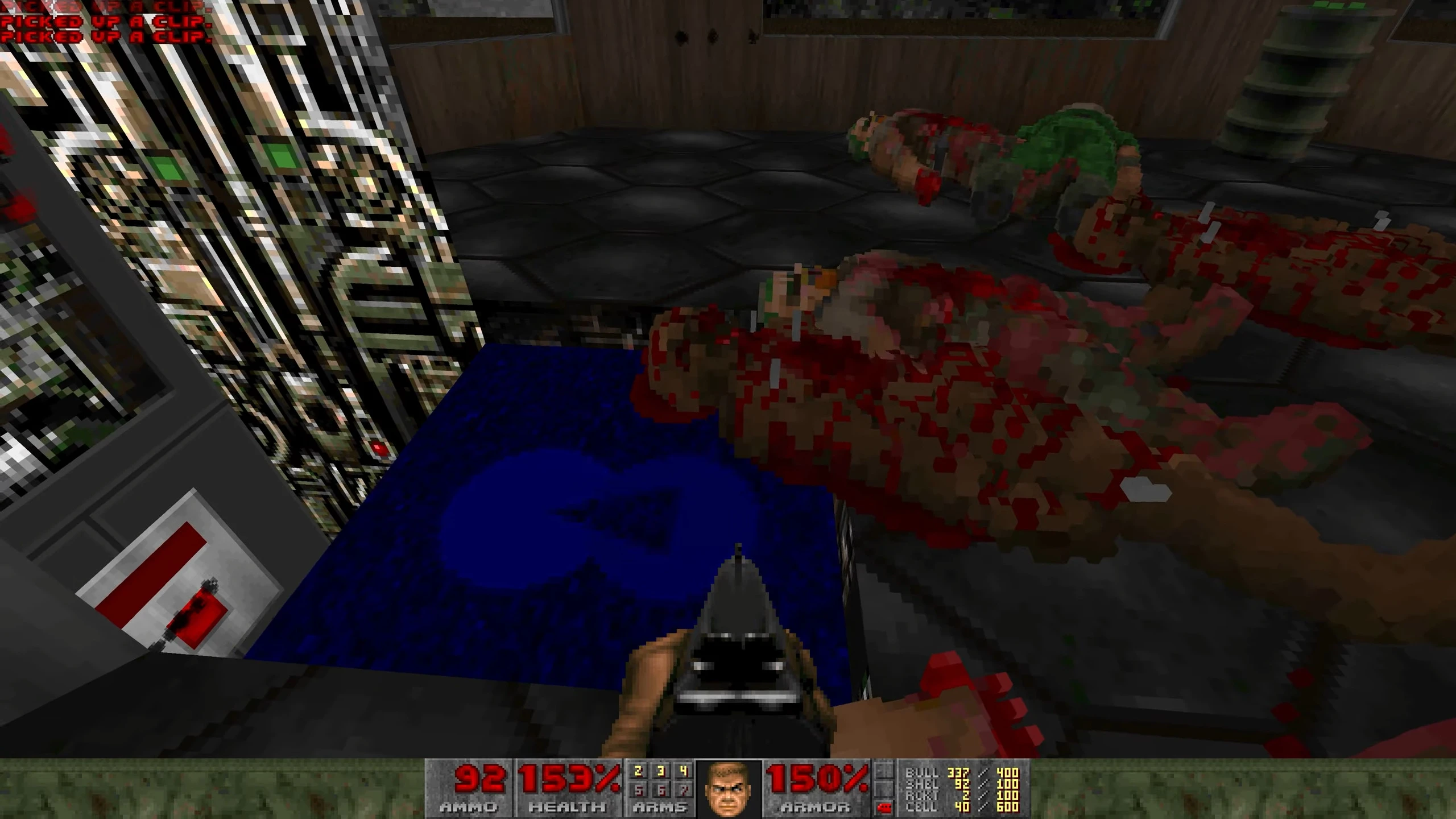 Doom 1993 gameplay screenshot showing pixelated dead enemies lying on the floor and a gun aimed forward in Voxel Doom mod