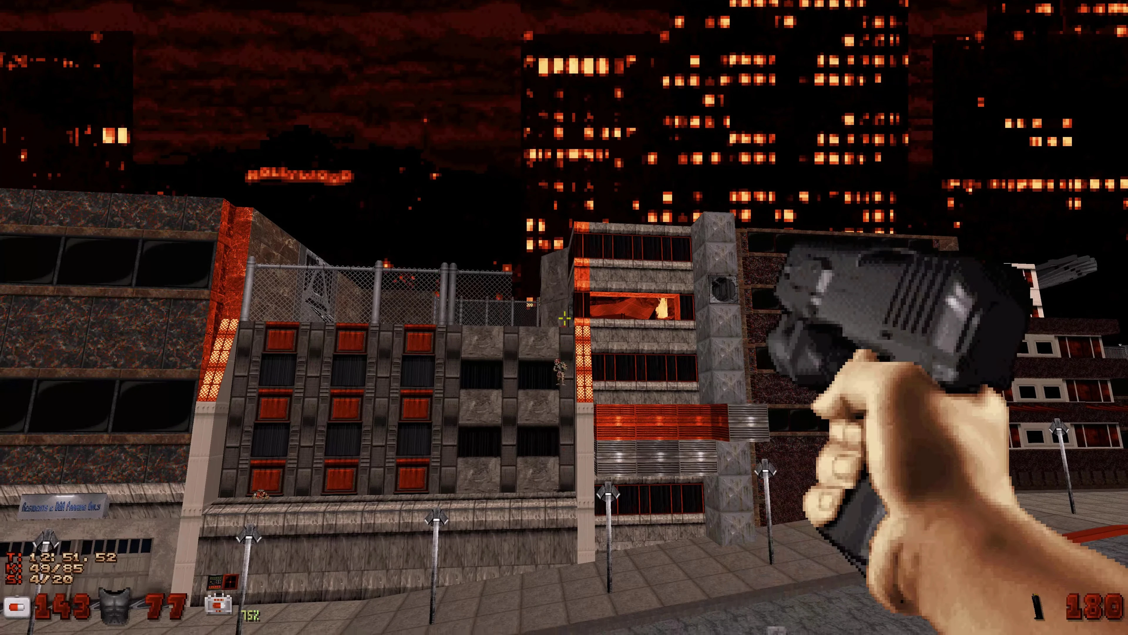 Vista en primera persona de una pistola apuntando a edificios de la ciudad iluminados por luces nocturnas naranjas en el mod Blast Radius de Duke Nukem 3D