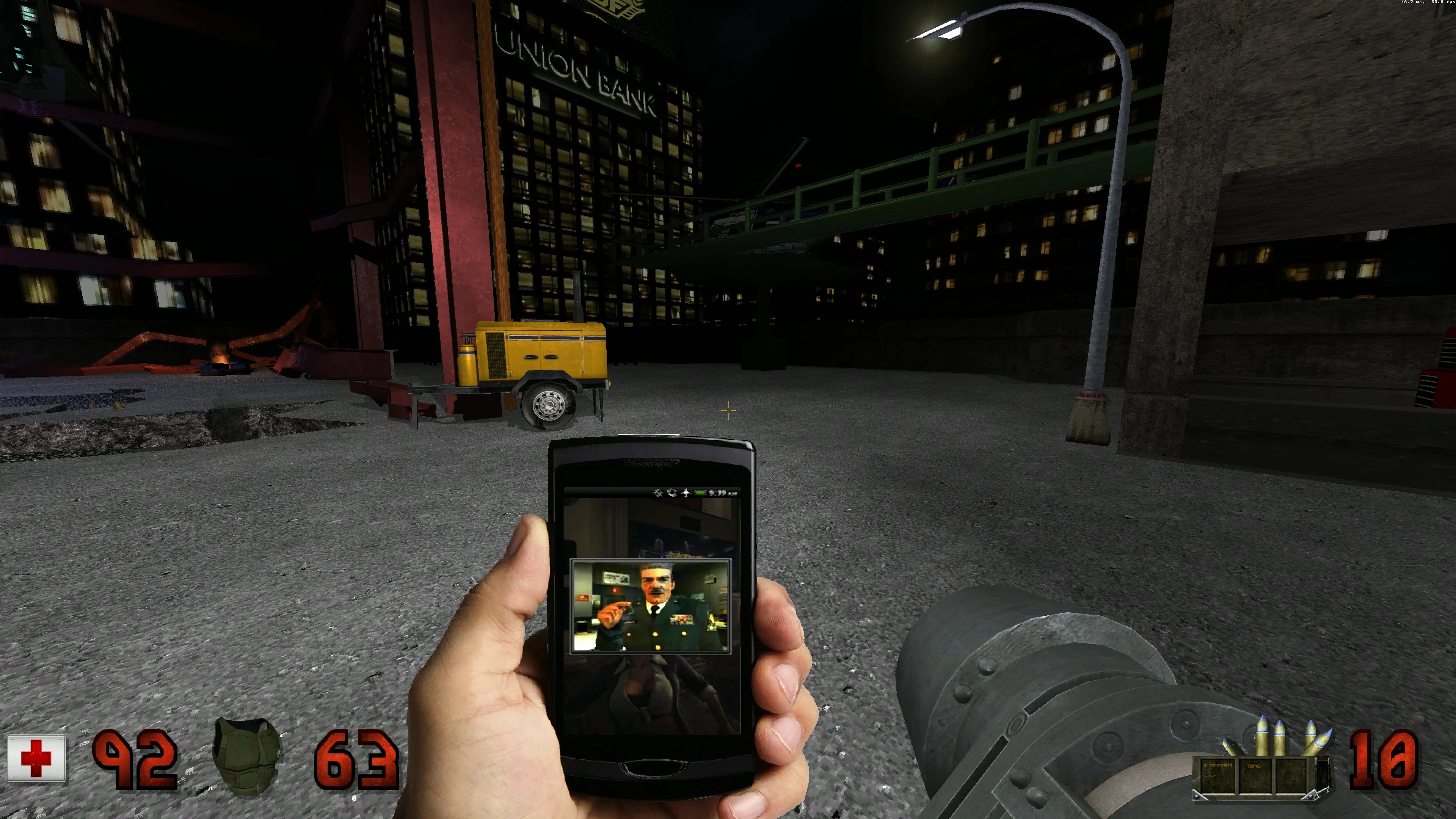 Spieler hält ein Telefon mit einem Militäroffizier auf einer dunklen Stadtstraße mit Gebäuden und Baumaschinen im Duke Nukem 3D Mod