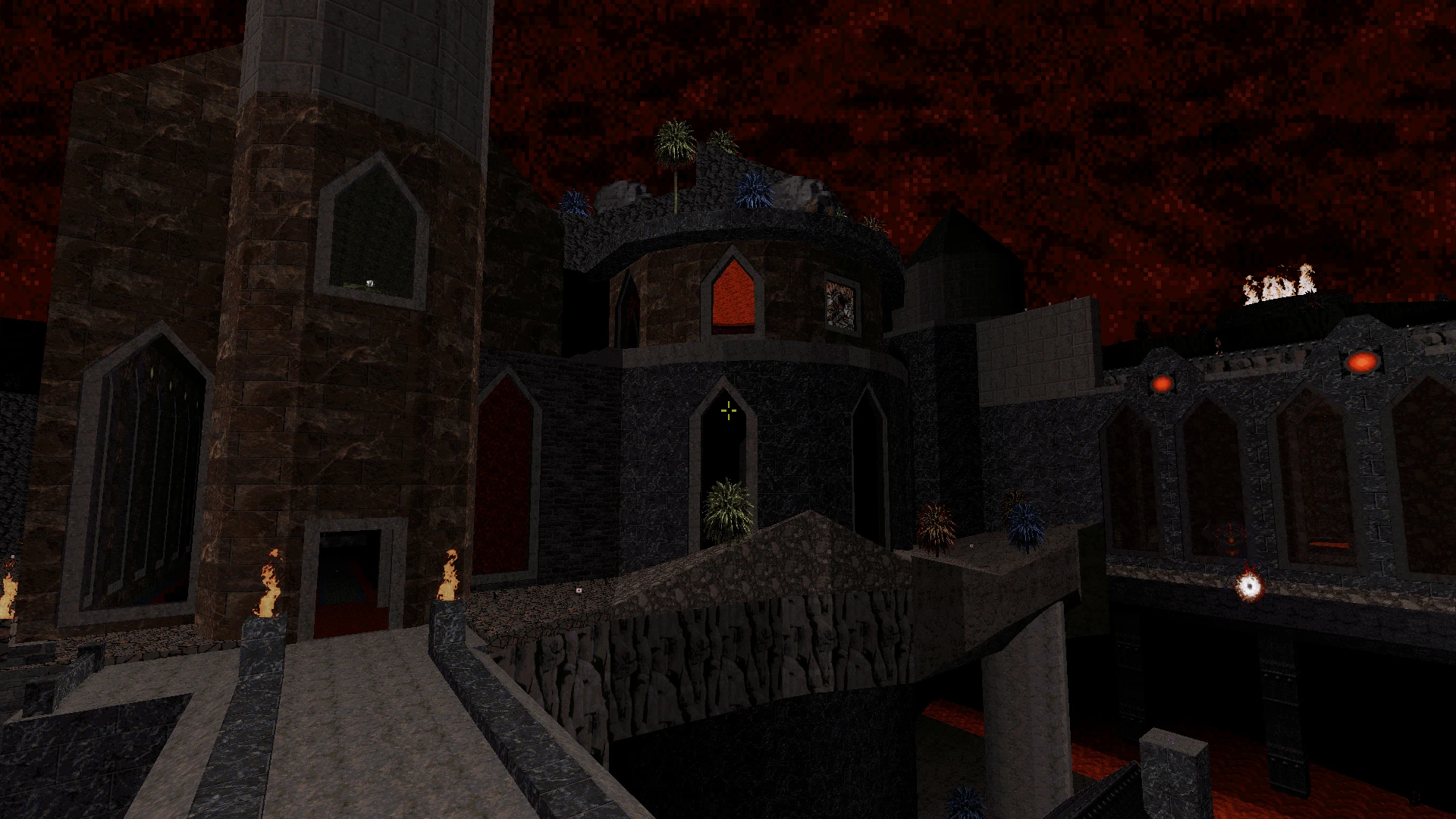 Captura de pantalla de un castillo medieval oscuro con puentes de piedra y antorchas encendidas bajo un cielo rojo en el mod Zombie Nukem de Duke Nukem 3D