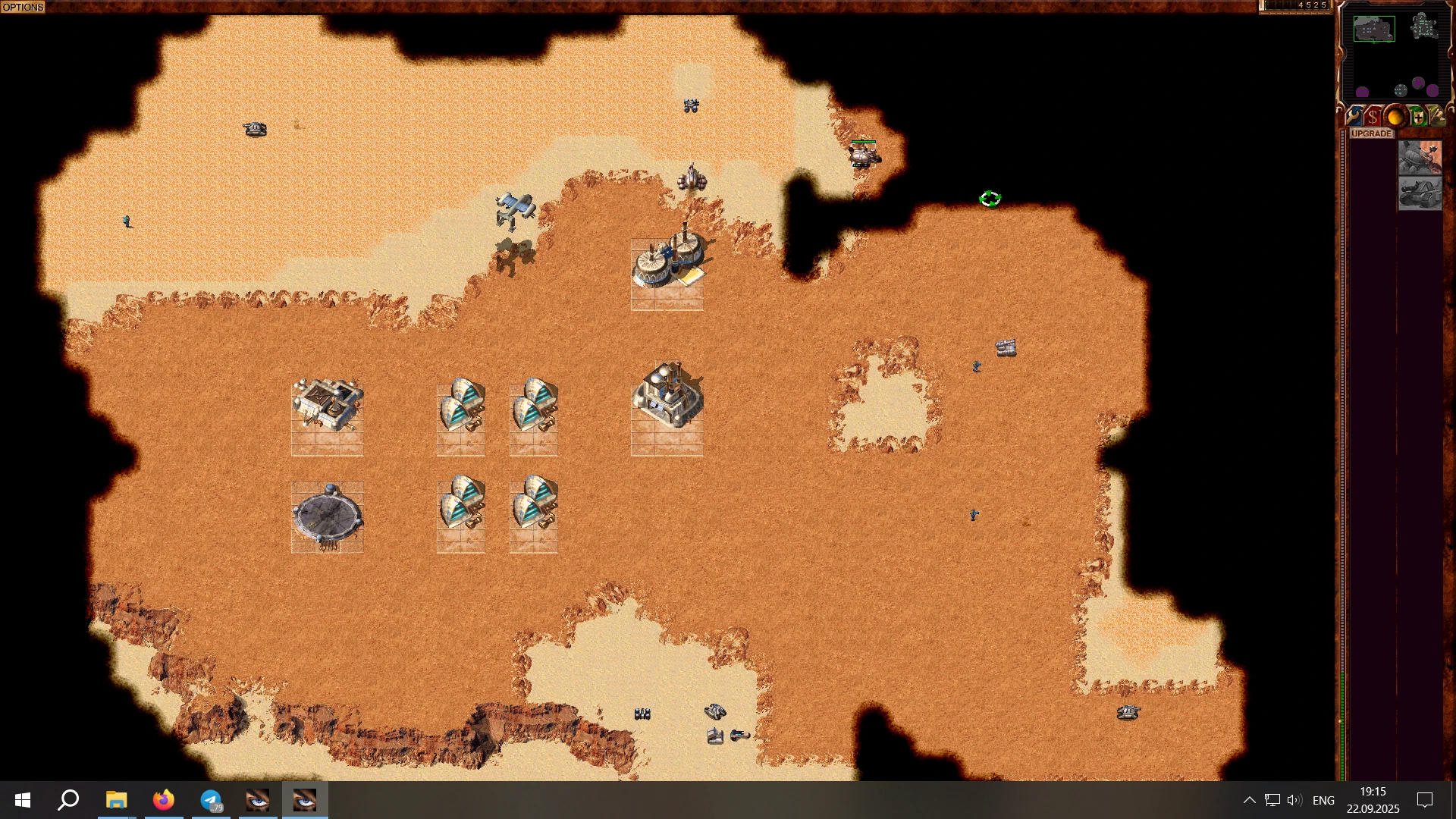 Top-Down-Ansicht einer Dune 2000 Spielkarte mit Gebäuden, Fahrzeugen und Geländedetails