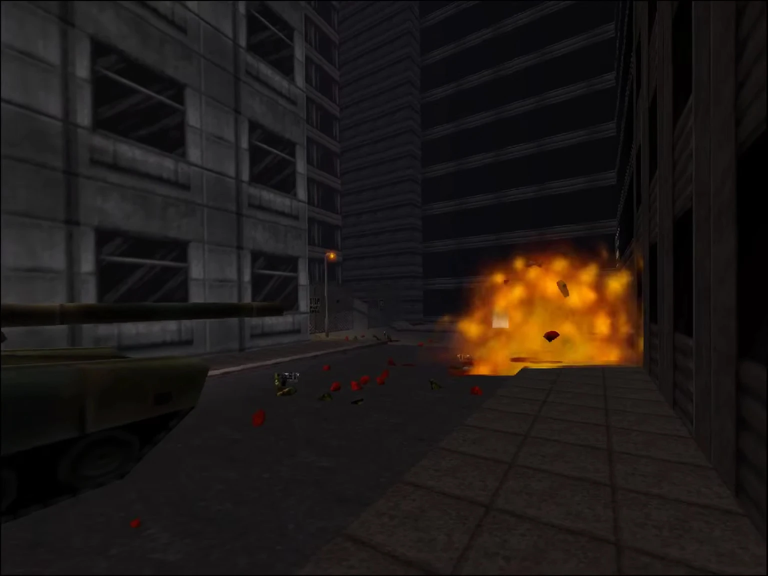 Ігровий процес Duke Nukem 3D з вибухом на темній міській вулиці, видно уламки та танк