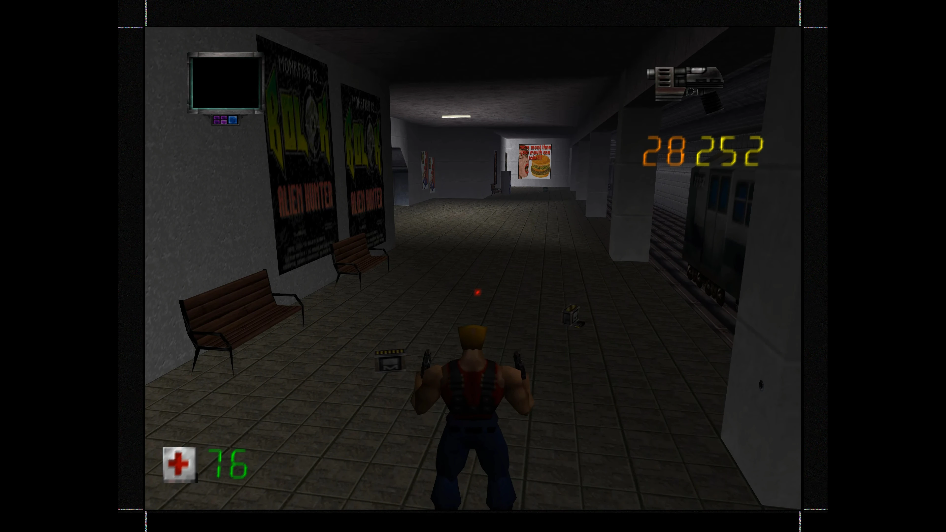 Duke Nukem-Charakter steht im U-Bahn-Gang mit Bänken, Postern und digitalem Countdown-HUD