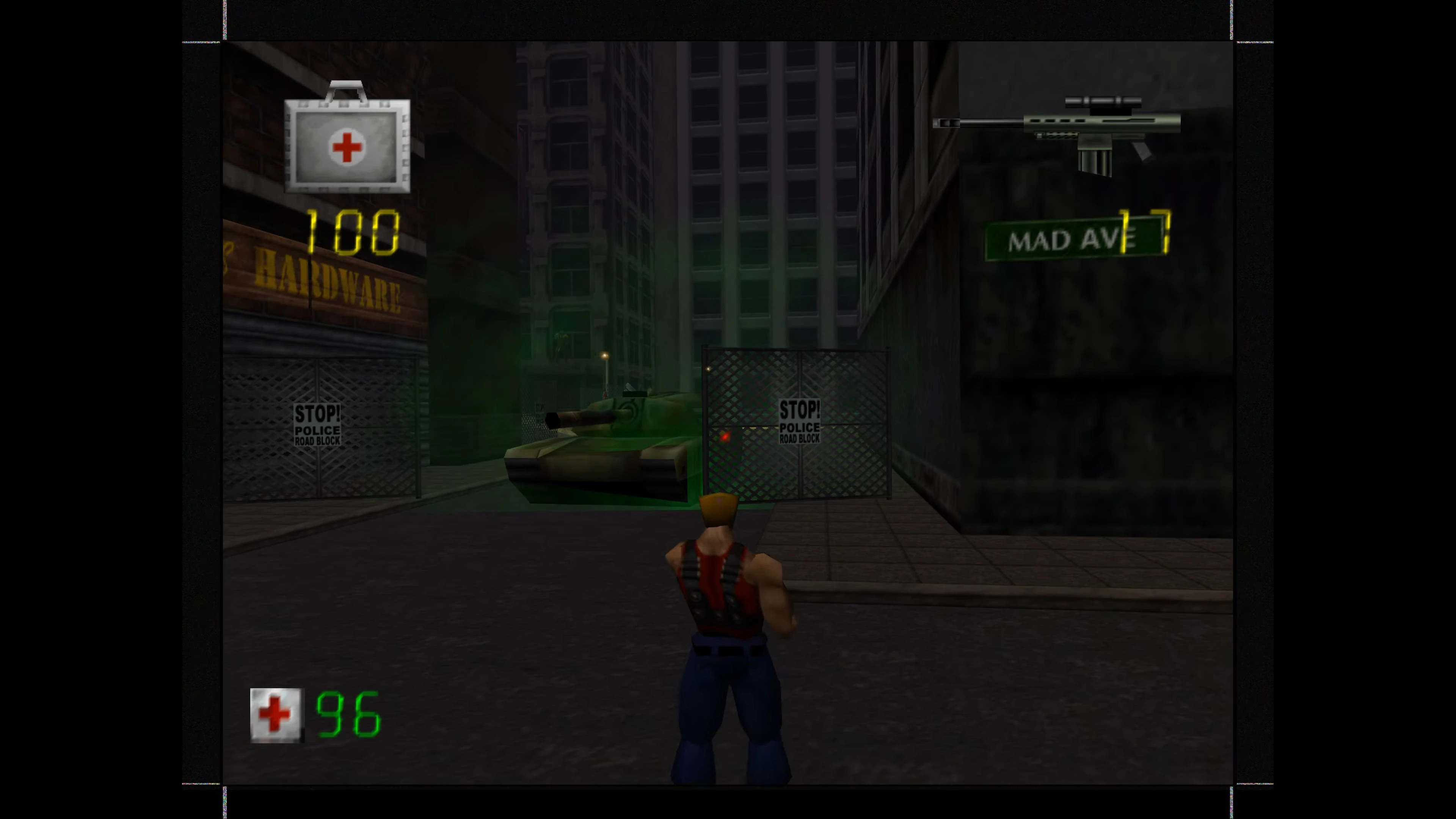 Spielerfigur steht mit dem Rücken zur Kamera vor einem Panzer und Polizeisperren in einer dunklen Stadt in Duke Nukem Zero Hour