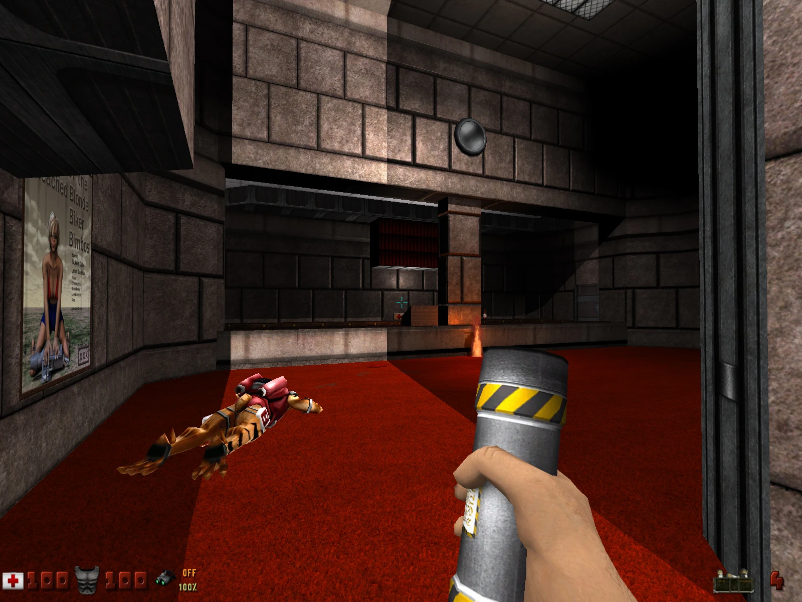 Zrzut ekranu z Duke Nukem 3D pokazujący gracza trzymającego cylindryczny przedmiot w pokoju z czerwonym dywanem i pokonanym przeciwnikiem