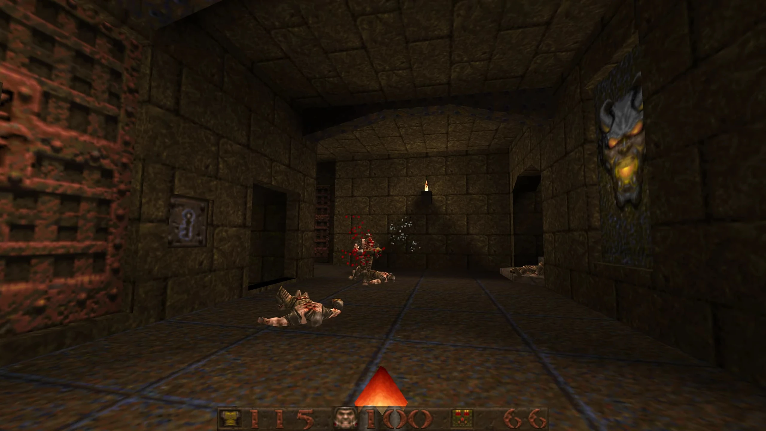 In-game screenshot from Quake 1996 featuring dark dungeon corridor, two fallen enemies, and an active combat scene with blood effects