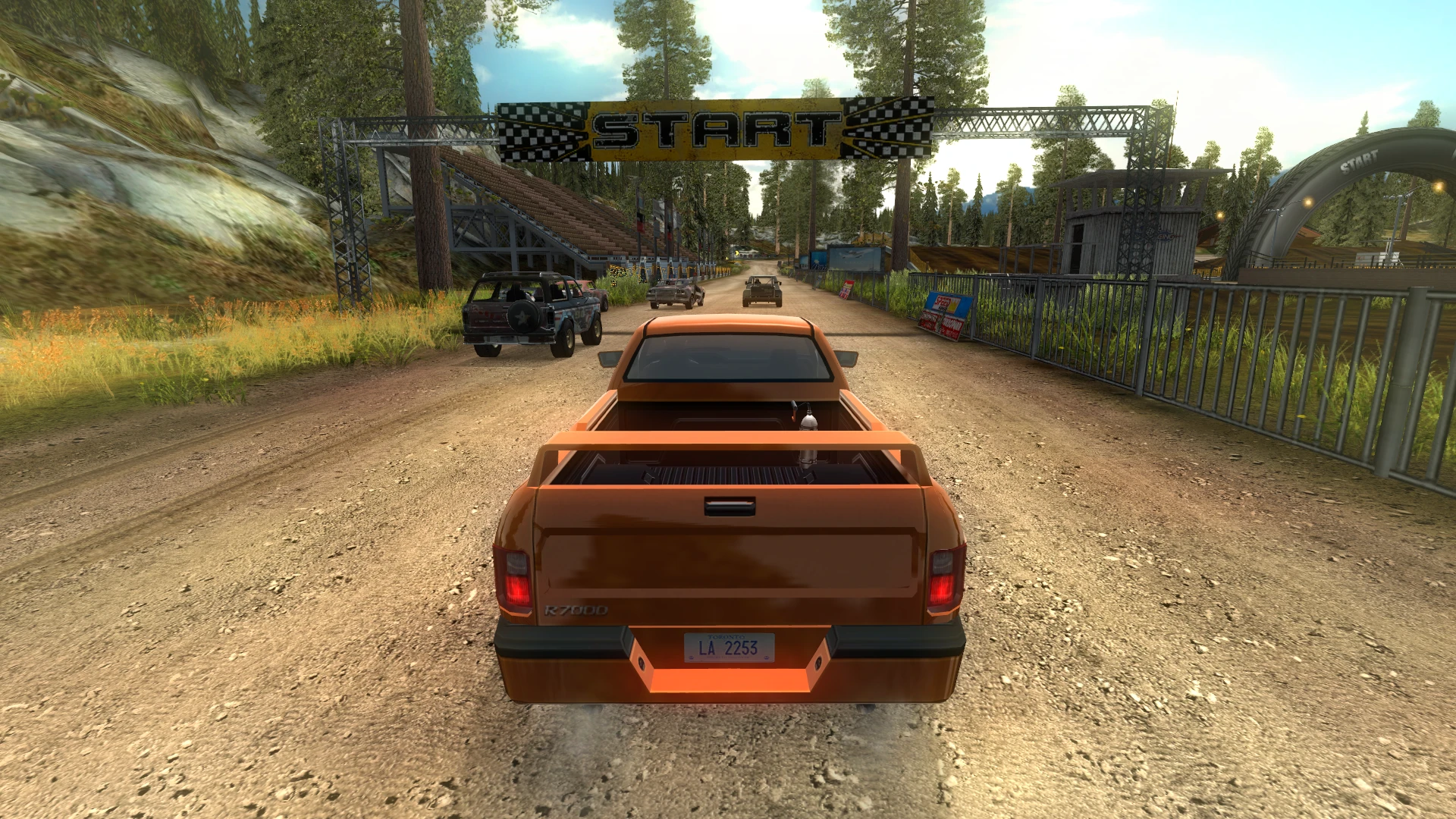 Rear view of an orange pickup truck waiting at the starting line in a dirt track race in FlatOut 2