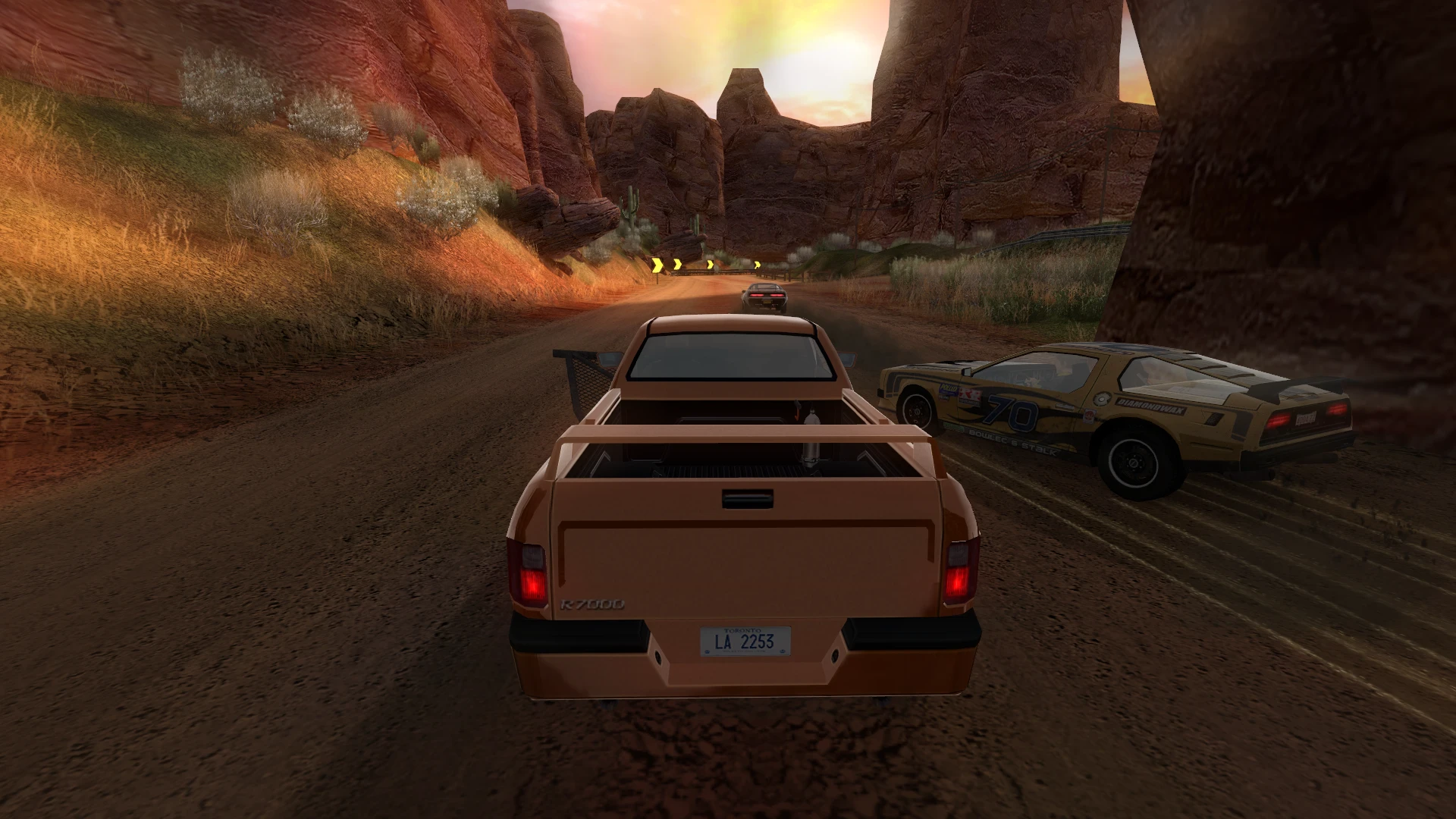 In-game screenshot showing normal cars racing on a desert canyon dirt road in FlatOut 2 mod