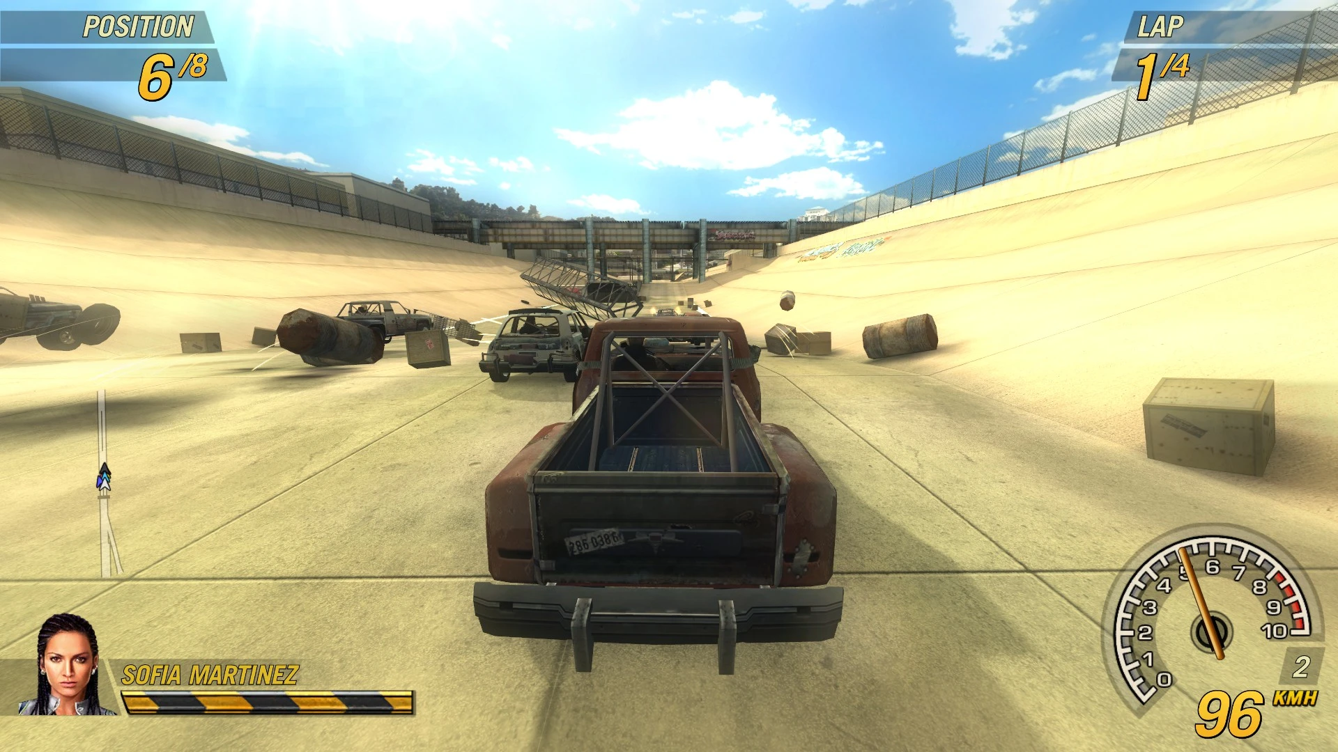 Juego de FlatOut 2 mostrando una camioneta oxidada en una arena de demolición con escombros esparcidos en la pista