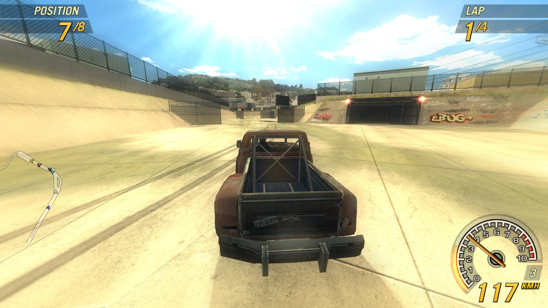 Coche de carreras conduciendo por circuito urbano de cemento bajo el sol en FlatOut 2 con mod MapZoom