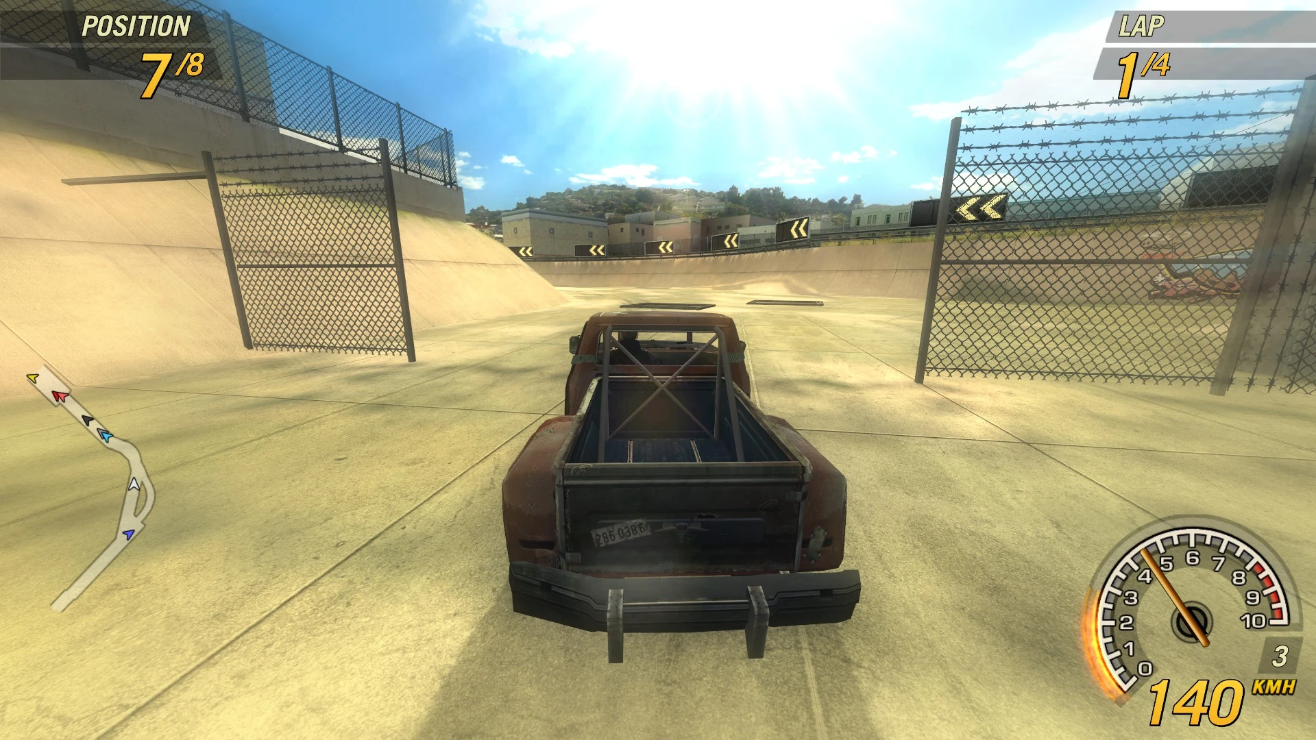 Vista dentro del juego desde detrás de una camioneta oxidada corriendo en una pista de concreto con vallas bajo luz solar brillante
