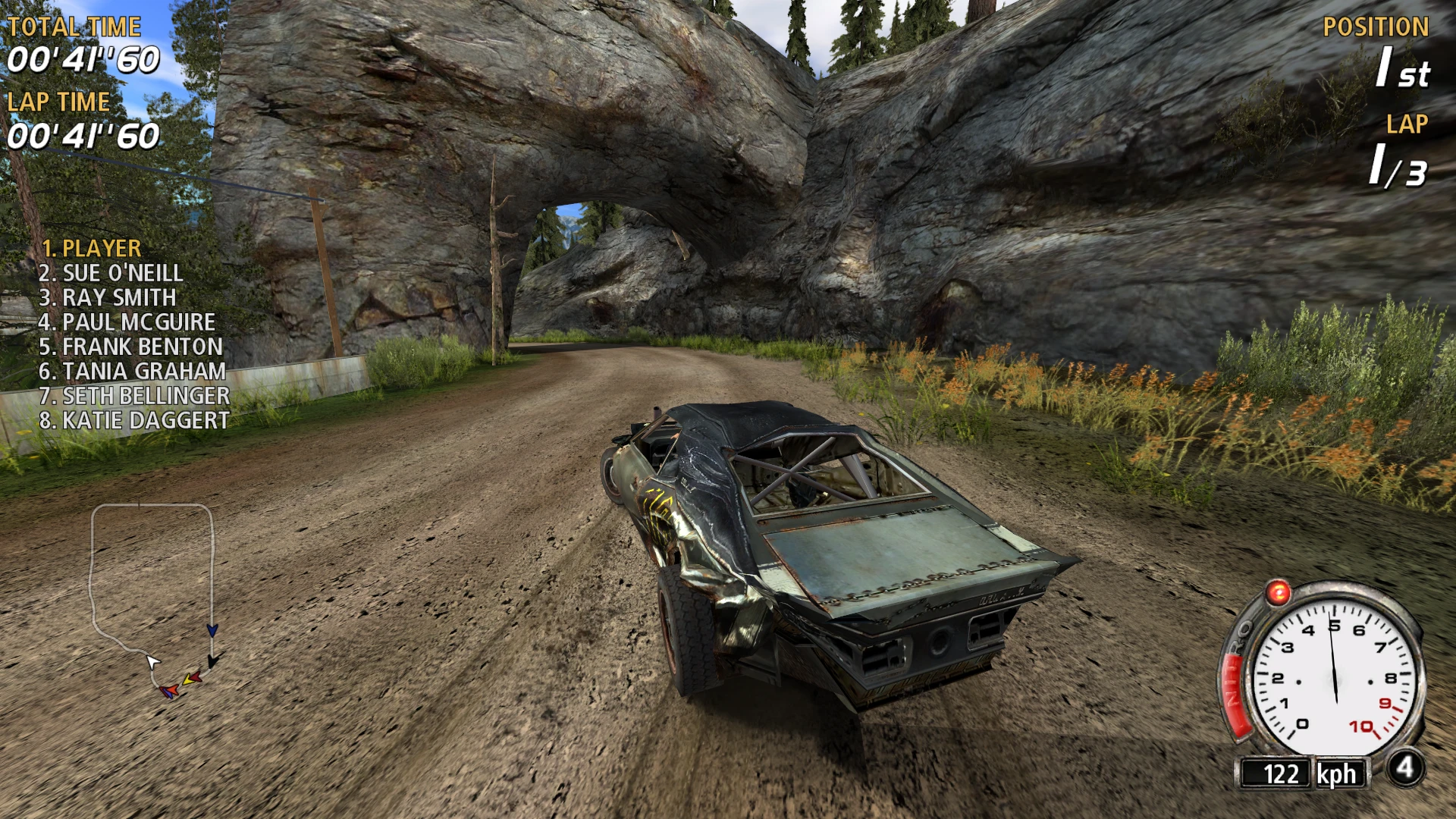 Beschädigtes Auto fährt auf Schotterstraße unter einem natürlichen Felsbogen in FlatOut 2004 mit Mod