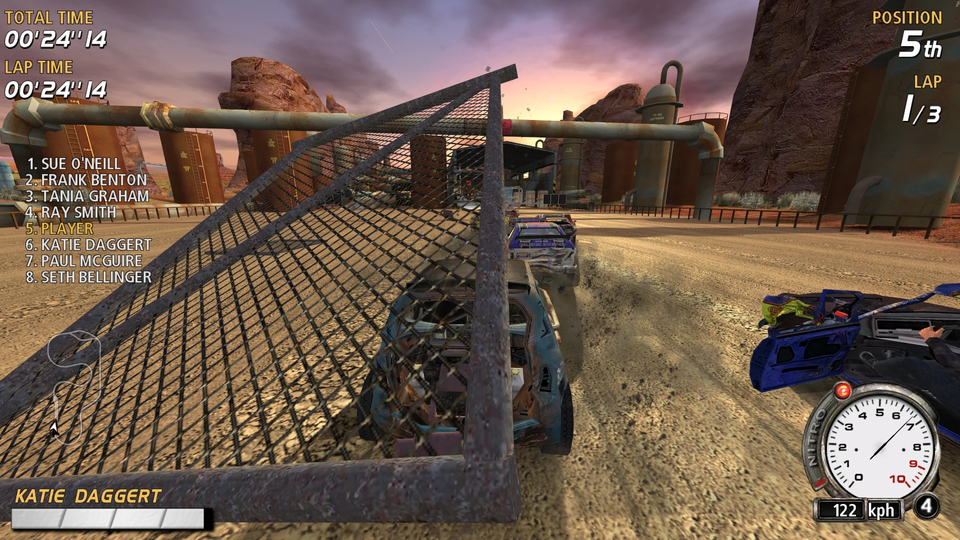 Blick hinter ein stark beschädigtes Auto, das auf einer Schotterstrecke mit Industriehintergrund im FlatOut 2004 Mod fährt