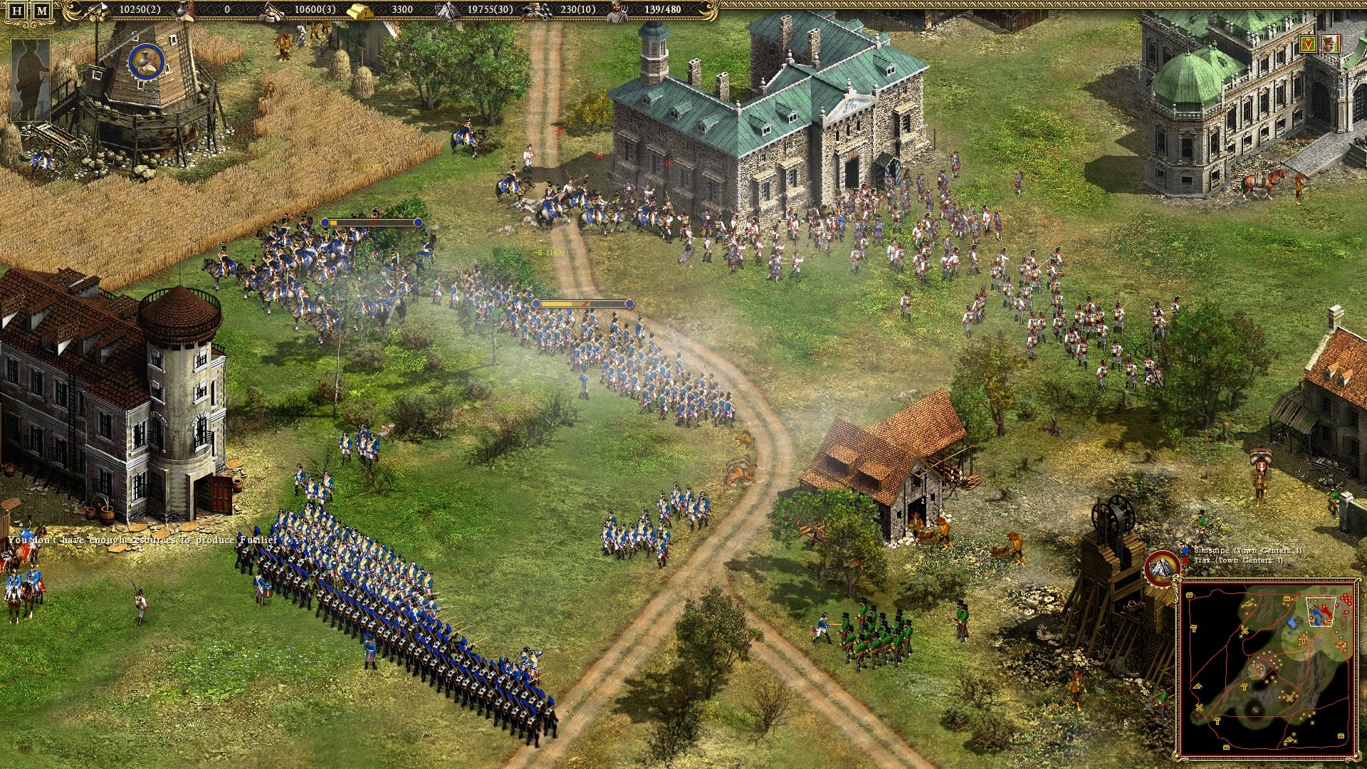 Draufsicht auf Soldaten in blauen und roten Uniformen, die nahe Gebäuden und Feldern im Strategiespiel Cossacks II kämpfen
