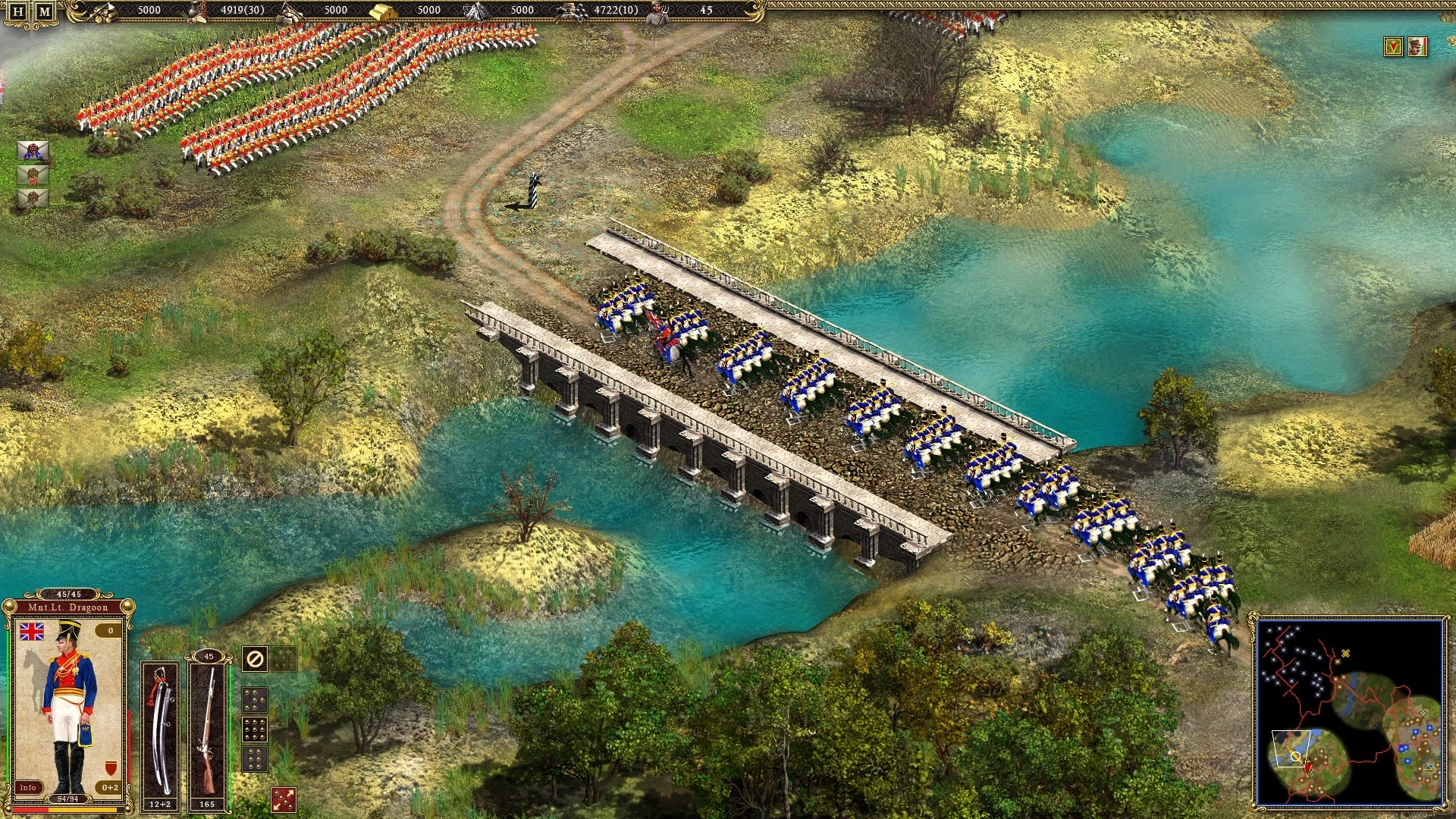Kavallerieeinheiten in blauen Uniformen überqueren eine Steinbrücke über einen Fluss, in der Nähe rot gekleidete Soldaten in einer Szene des Spiels Cossacks II Napoleonic Wars