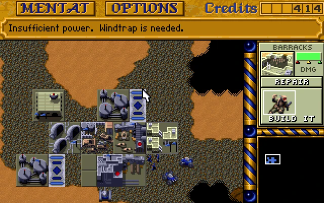 Top-down view of base buildings in Dune II showing power shortage warning and barracks repair option