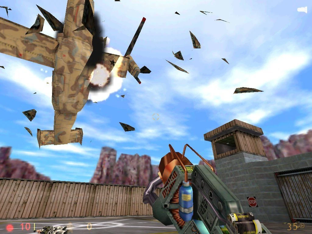 Screenshot from Half-Life (1998): helicopter explodes mid-air with debris flying, player holds Tau Cannon
