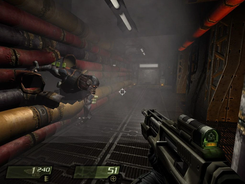 Vista en primera persona apuntando con arma futurista a un enemigo volador en un pasillo de alcantarilla con niebla en Quake 4