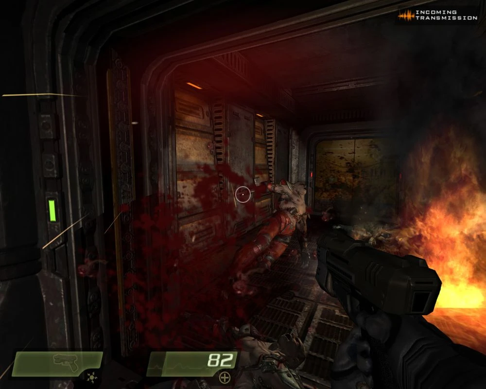 Vista en primera persona disparando a enemigos monstruosos en un pasillo tenuemente iluminado con fuego en Quake 4