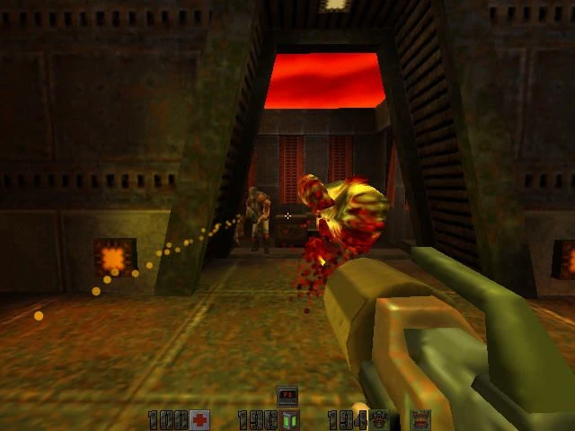 Ujęcie z pierwszej osoby w Quake II strzelające z karabinu plazmowego do dwóch humanoidalnych mutantów w metalicznym korytarzu