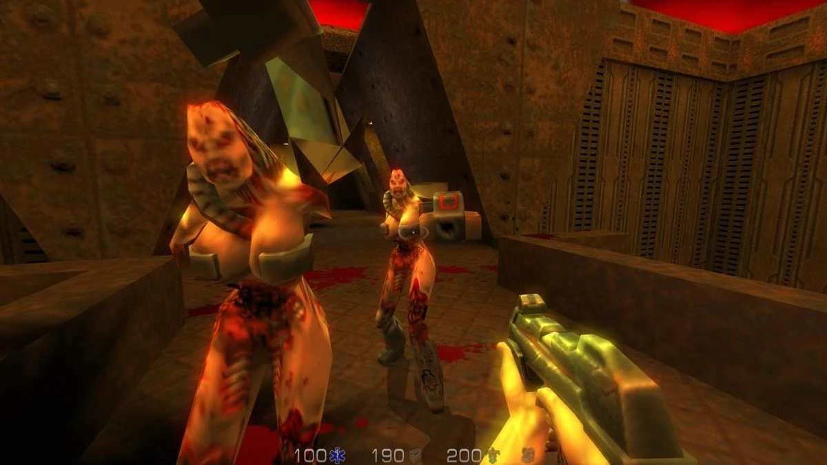 Widok z pierwszej osoby strzelający do humanoidalnych obcych w ciemnym przemysłowym korytarzu w Quake II
